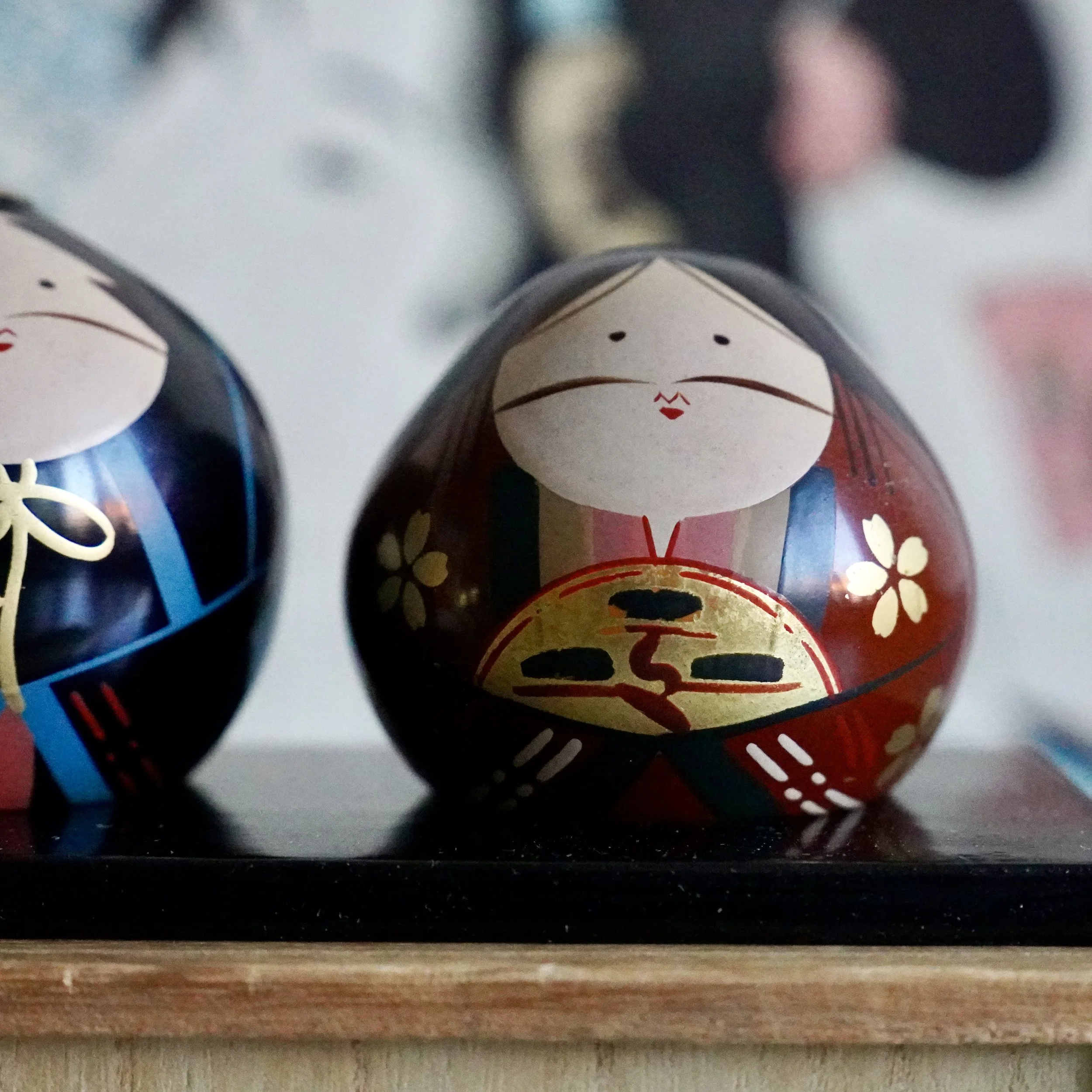 Ouchi-nuri hina doll pair front view, deep red bride doll with gold sakura and fan