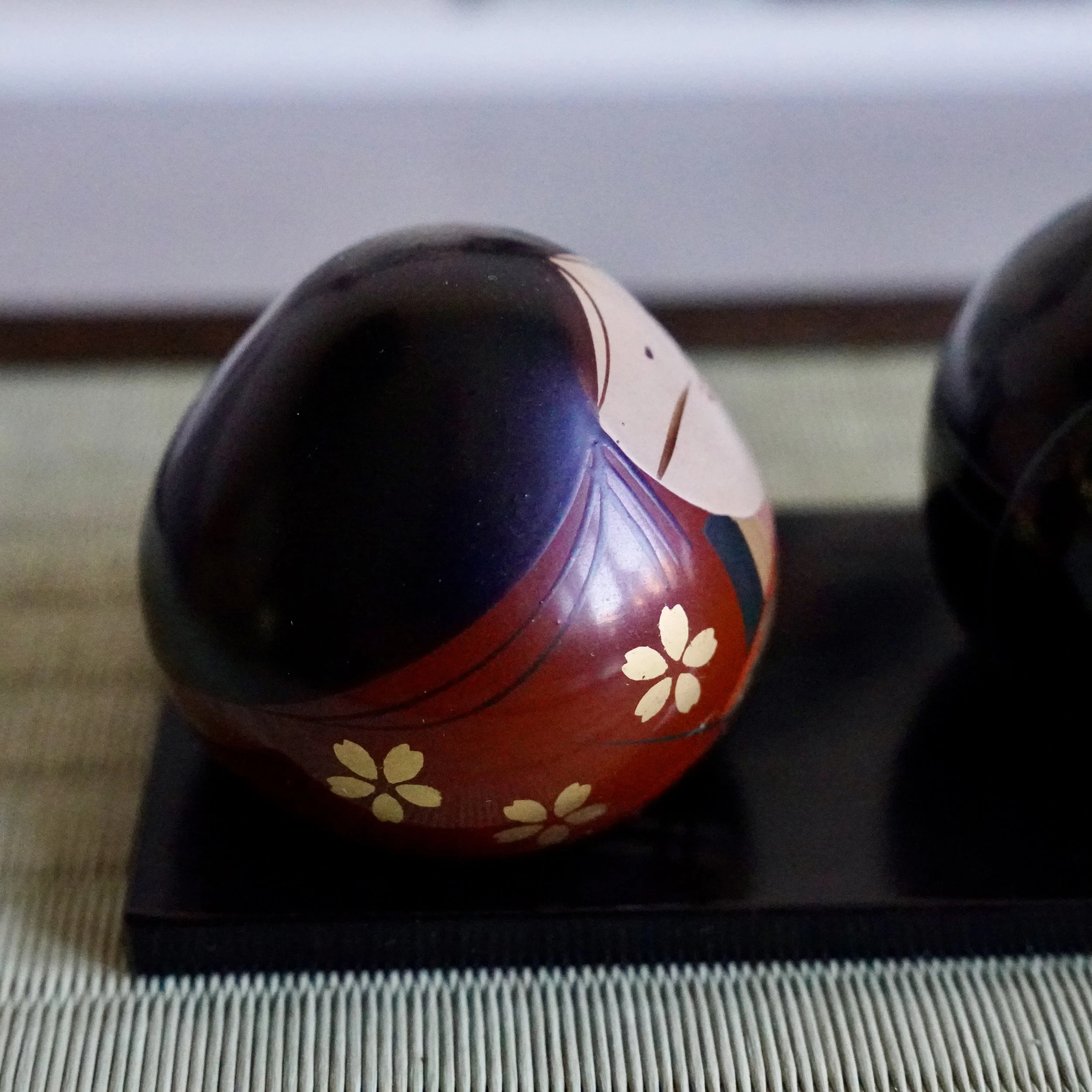 Ouchi-nuri bride hina doll back view, gold sakura decoration on deep red lacquer