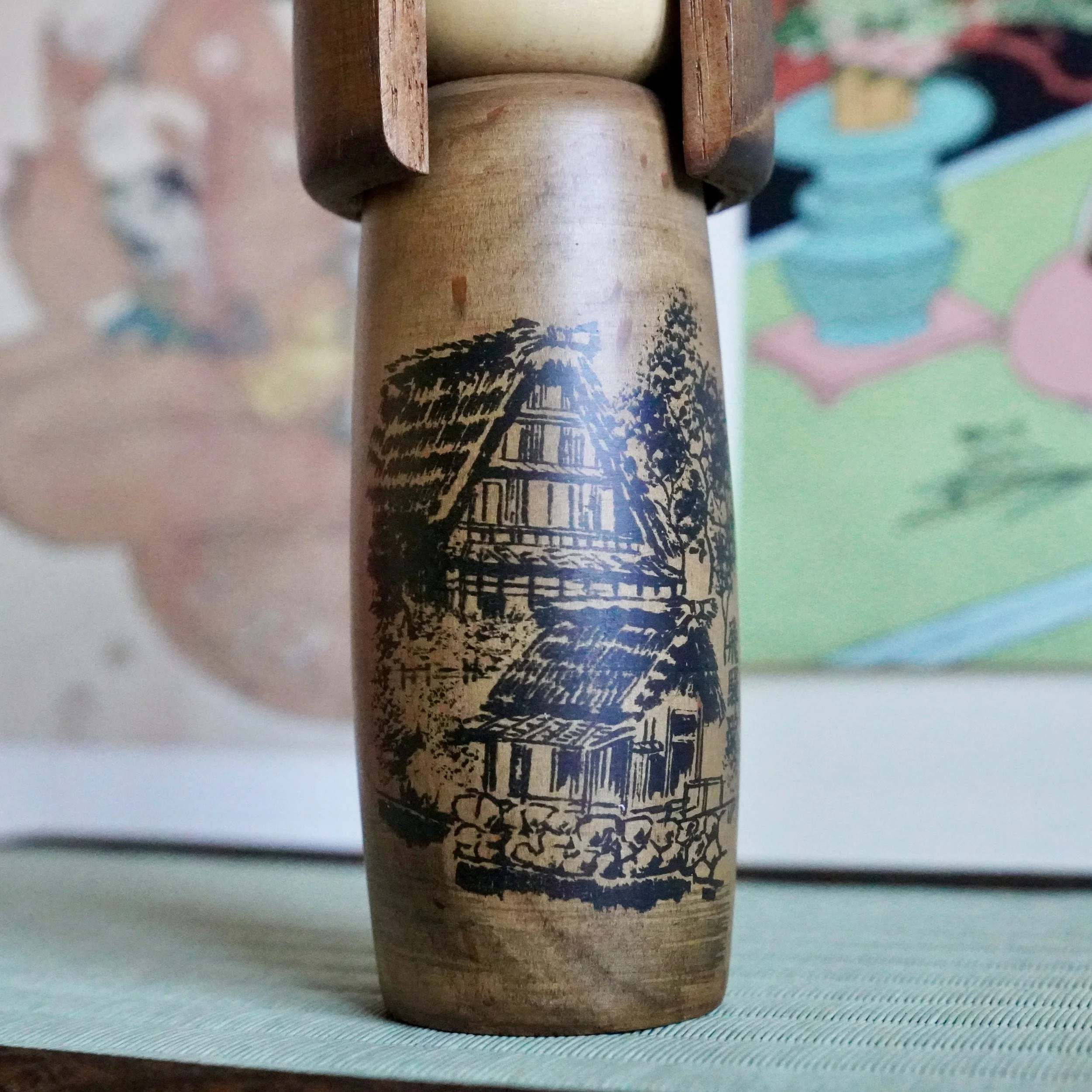 Painted Hida road farmhouse scene on Usaburō sōsaku kokeshi doll body