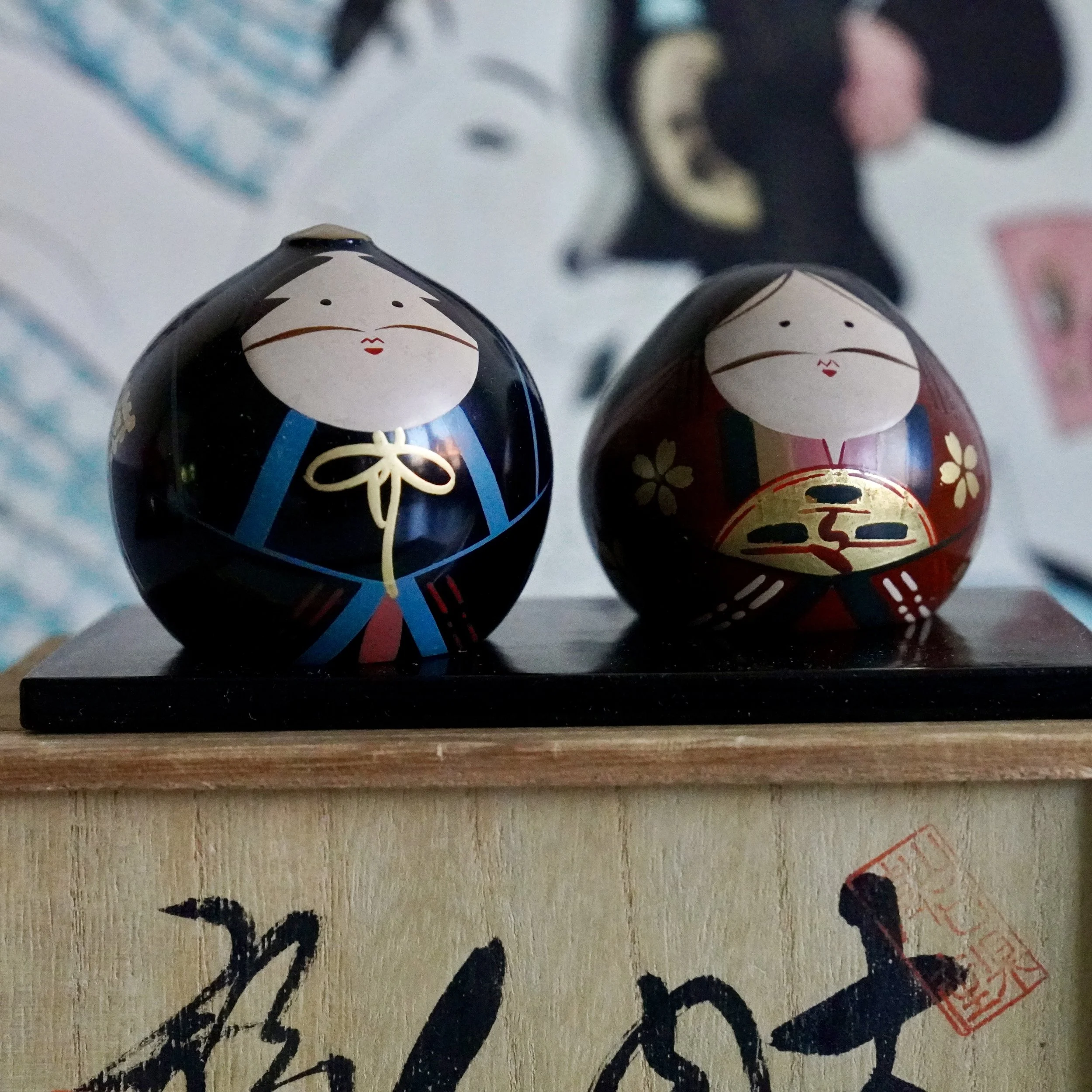 Ouchi-nuri bride and groom hina dolls standing on tomobako lid with hand-painted calligraphy