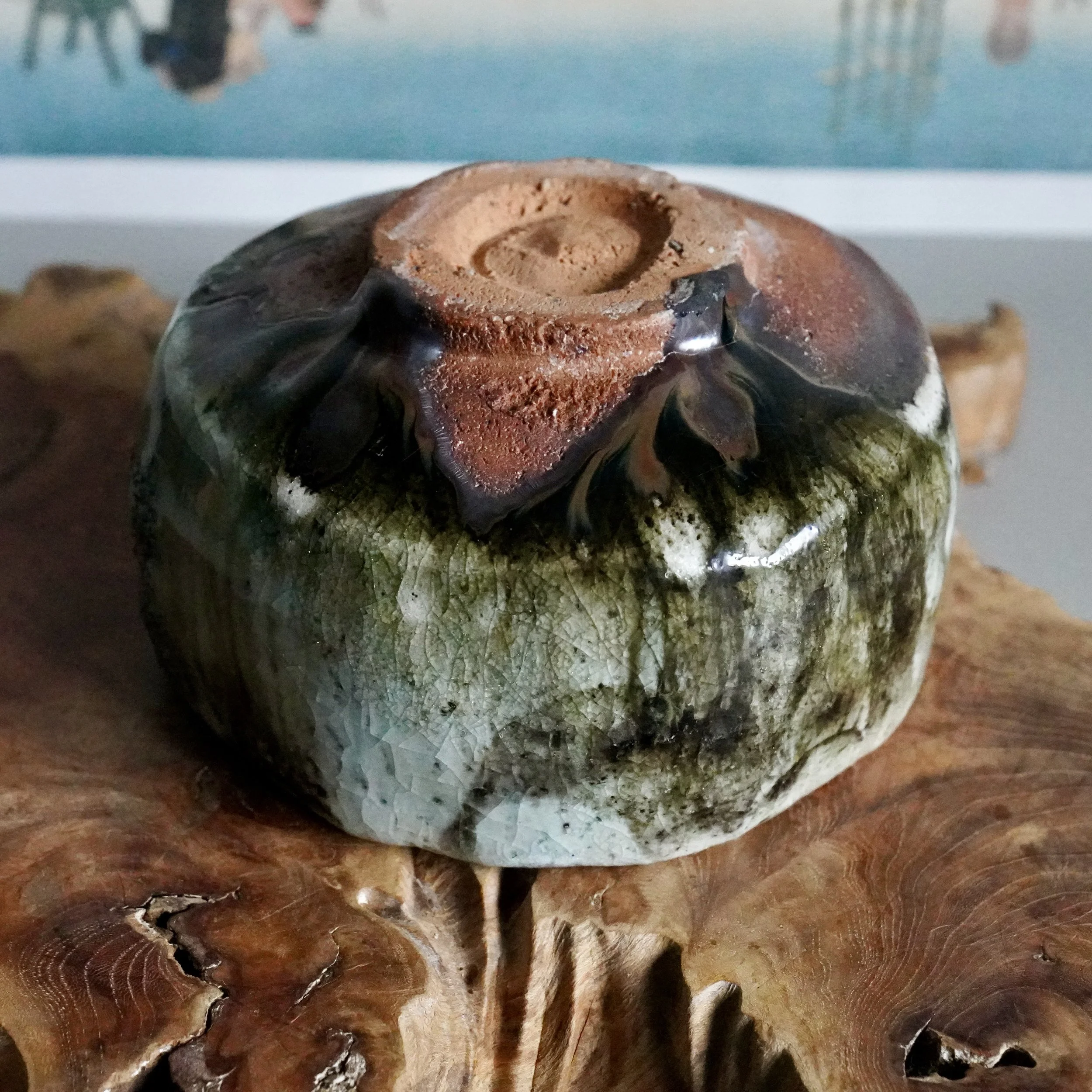 Wood-fired chawan by Deguchi Eiji, Kakuzan-gama, with an unglazed reddish-brown foot and crackled green-black-white glaze.
