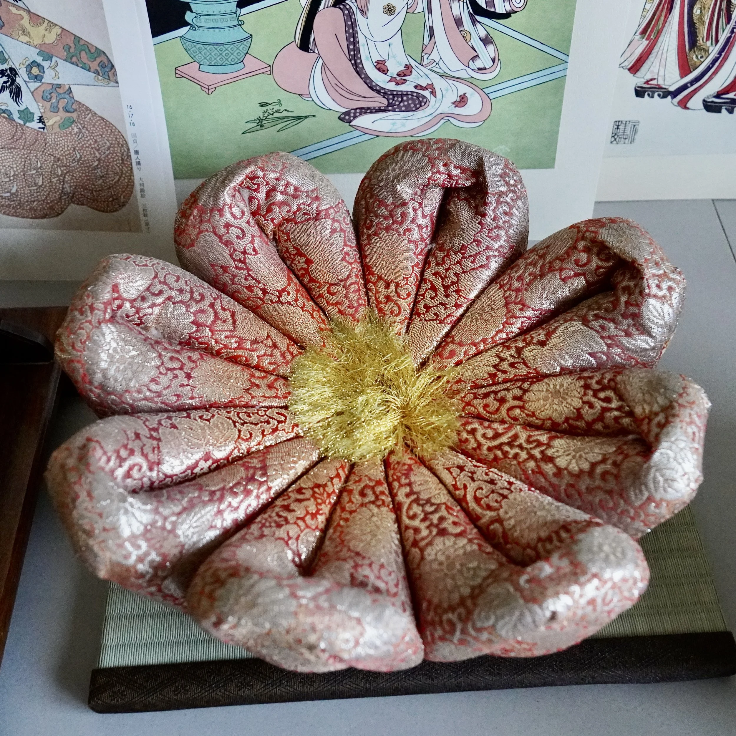 Red and gold brocade cushion shaped like an open flower for Japanese orin singing bowl