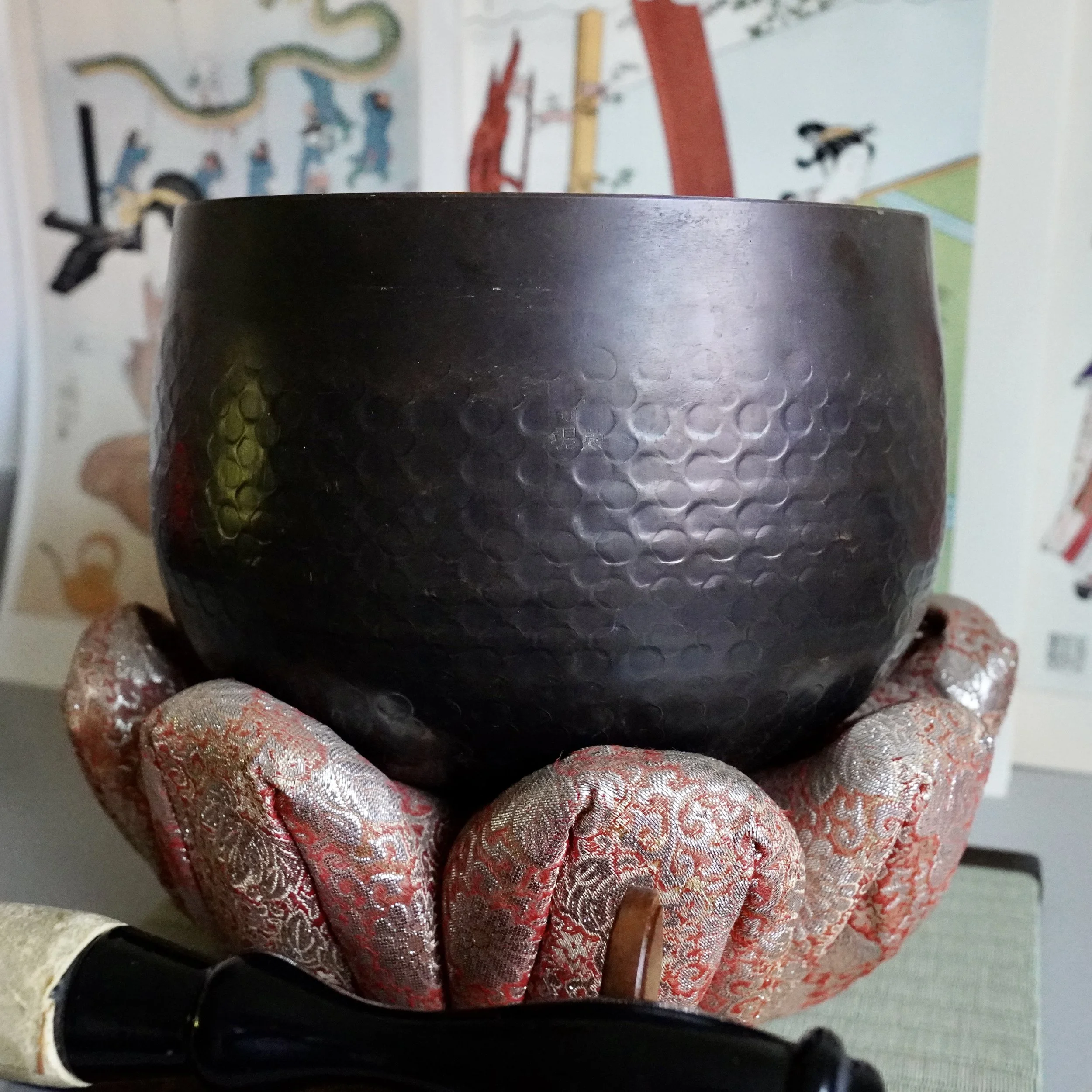 Signed Tsutsumi orin, Japanese bronze singing bowl, with striker on brocade cushion, front view