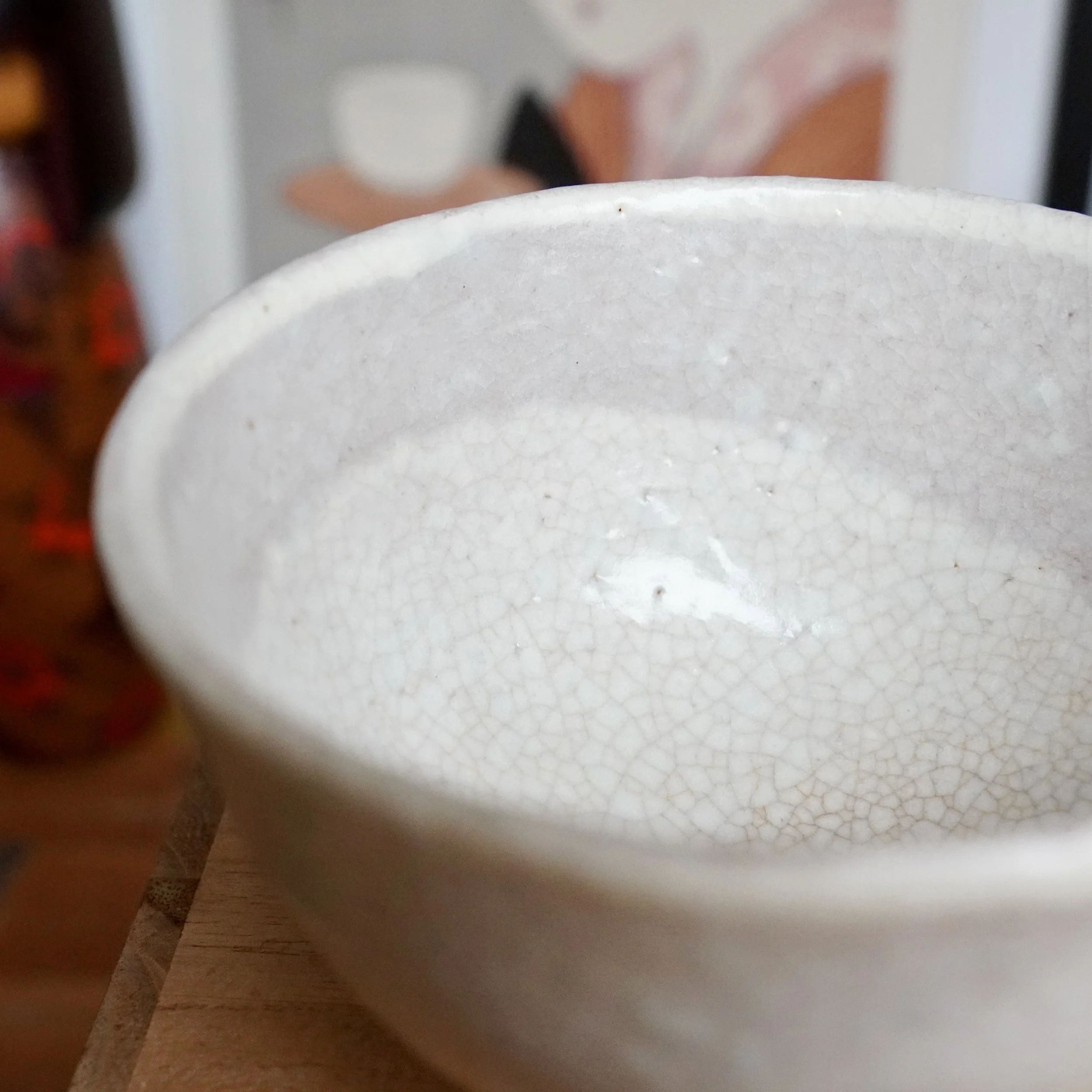 Angled interior view of a Hagi-yaki chawan by Tamamura Shōgetsu, featuring an off-white crackled glaze with tea stains.