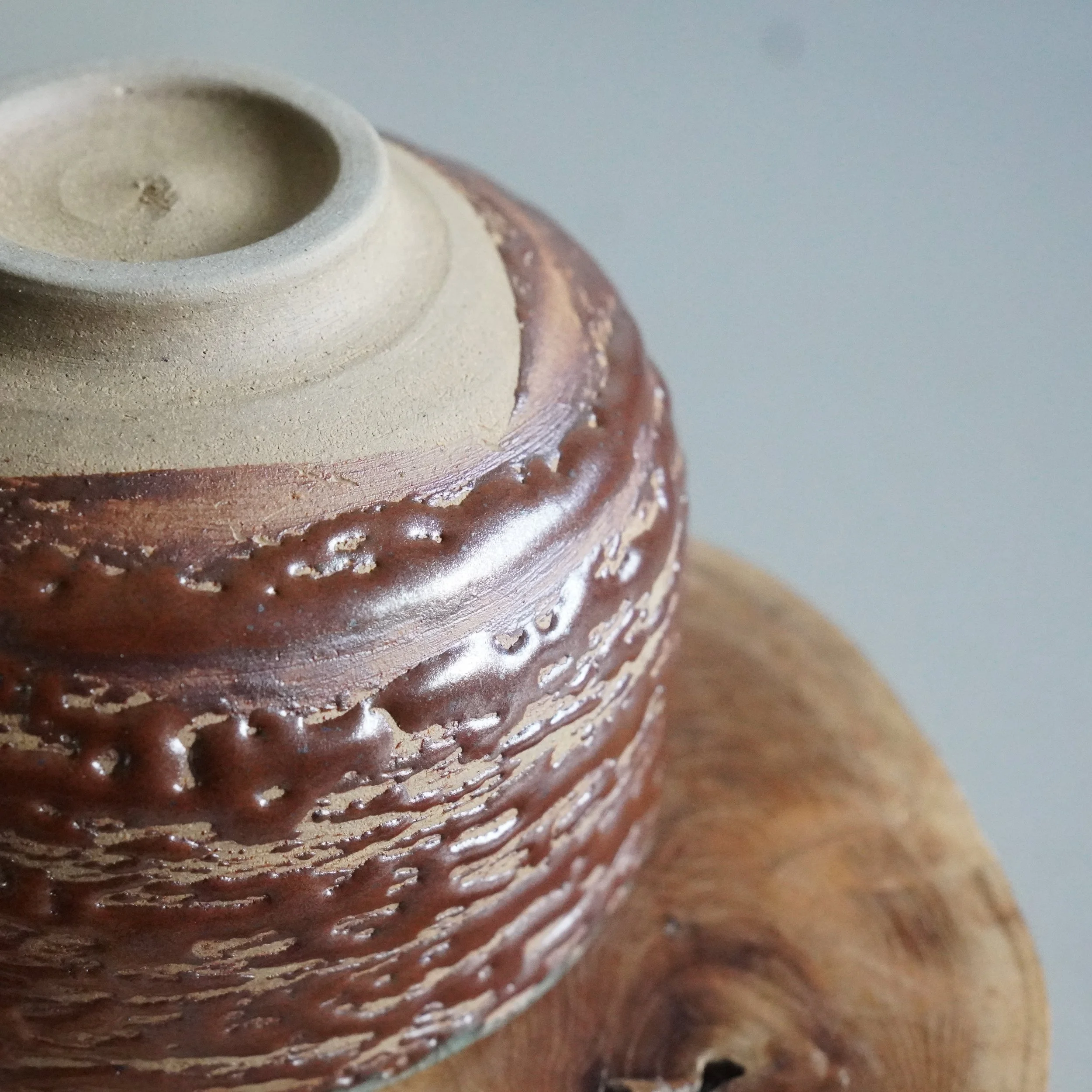 Close-up of matsukawa bark glaze texture on Inuyama-yaki chawan rim, deep brown crackled surface