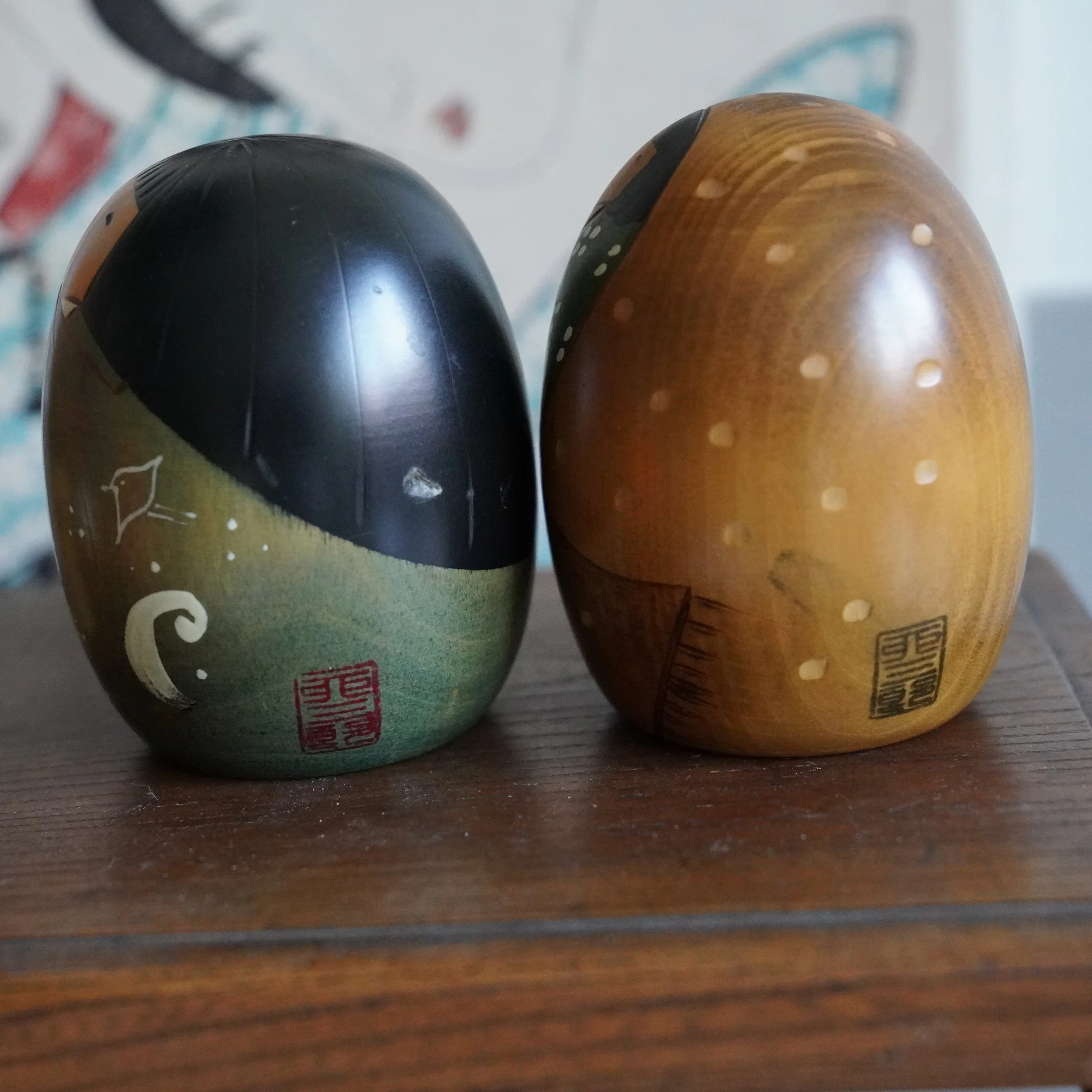 Back angle of vintage Usaburo kokeshi pair, black lacquered tops, egg shaped sosaku kokeshi, Showa period Japan