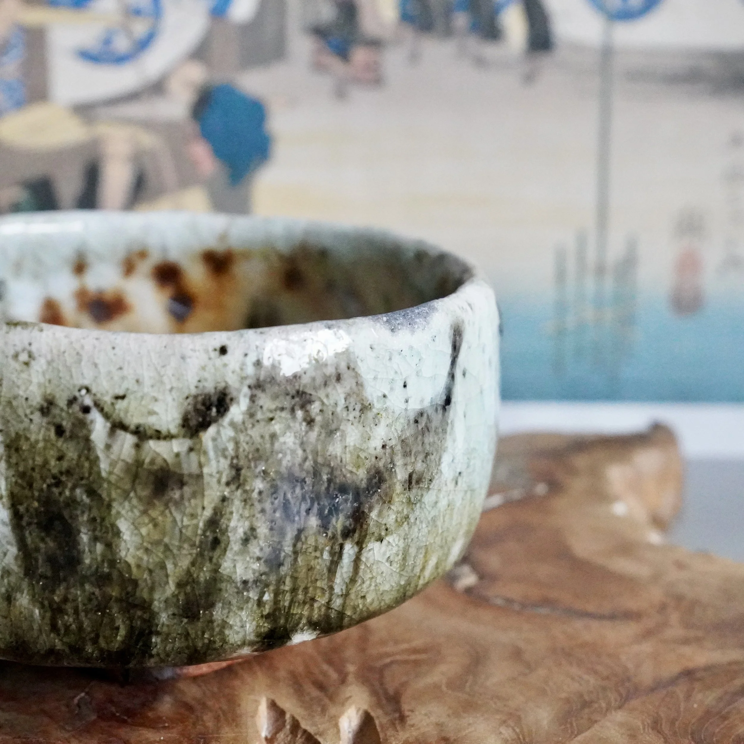 wood-fired chawan showing rust fire marks and a moss green glazed interior