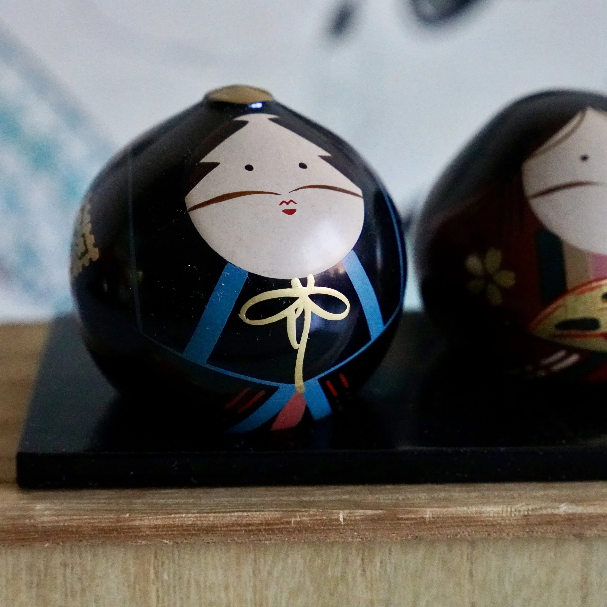 Ouchi-nuri lacquer hina doll pair, three-quarter angle, black and deep red lacquer on tomobako