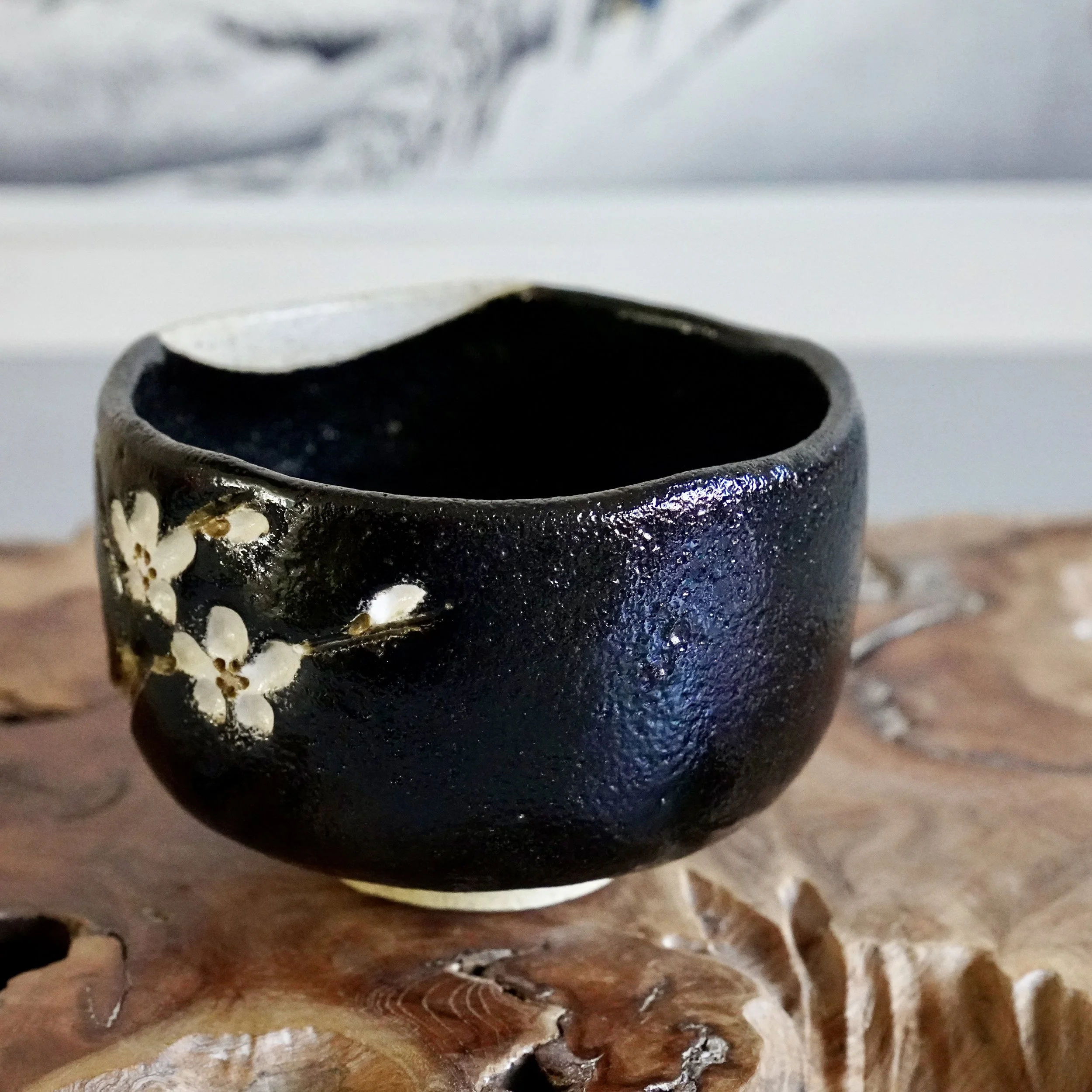 Kuro chawan with cherry blossom branch, kakiotoshi carved decoration