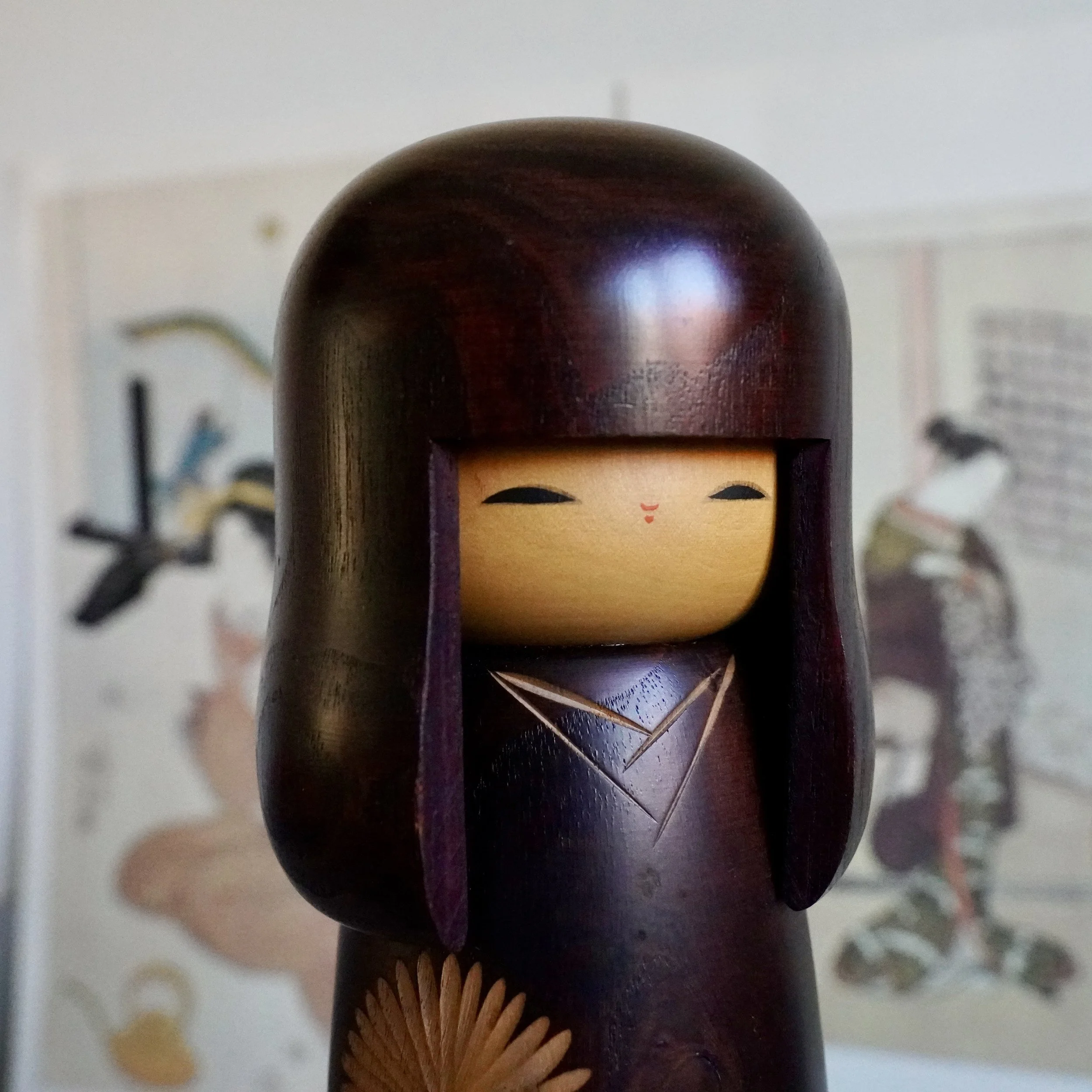 Usaburo kokeshi painted face close up, downcast eyes, dark stained wood, Showa period Japan
