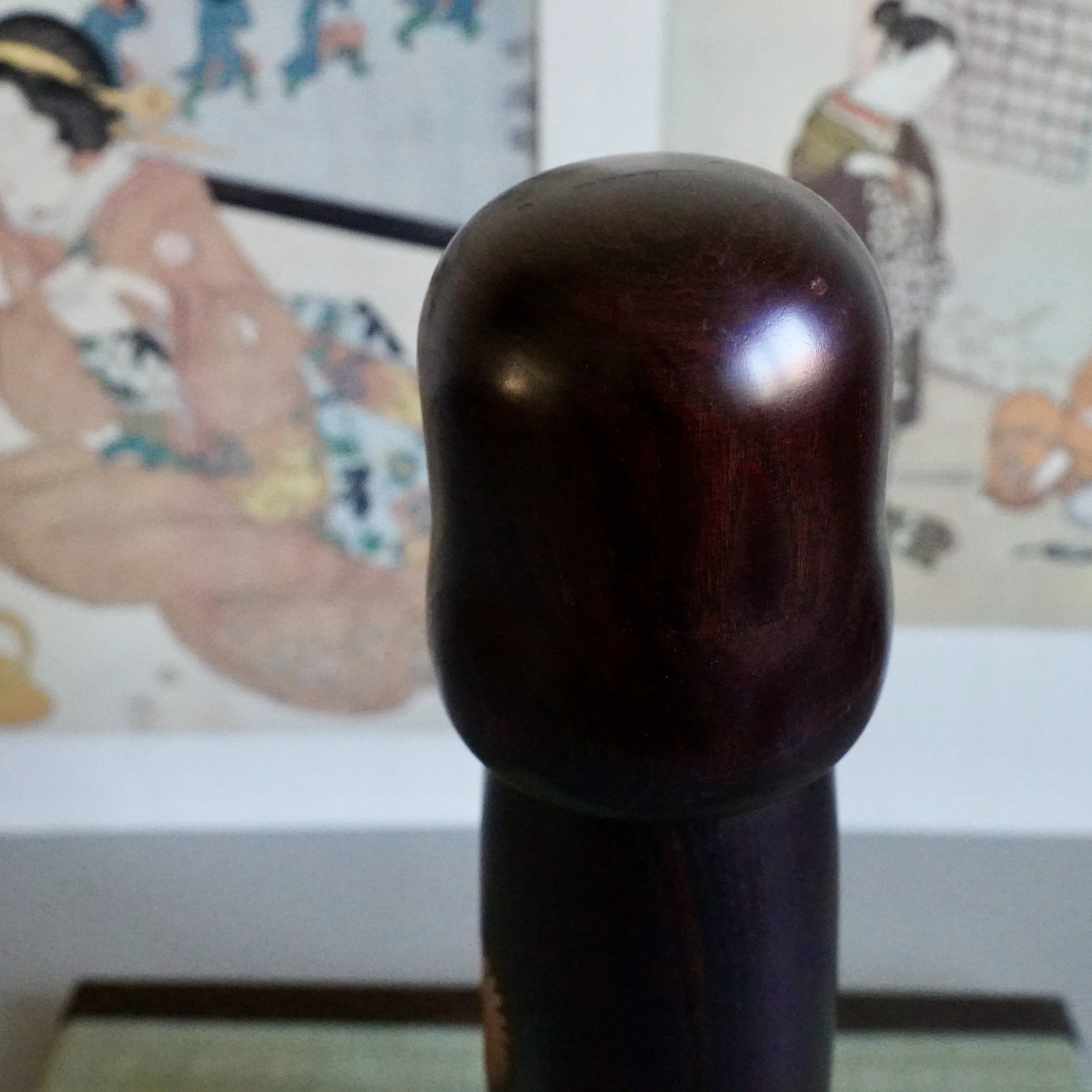 Usaburo kokeshi head close up, glossy dark stained wood dome, Showa period Gunma craftsmanship