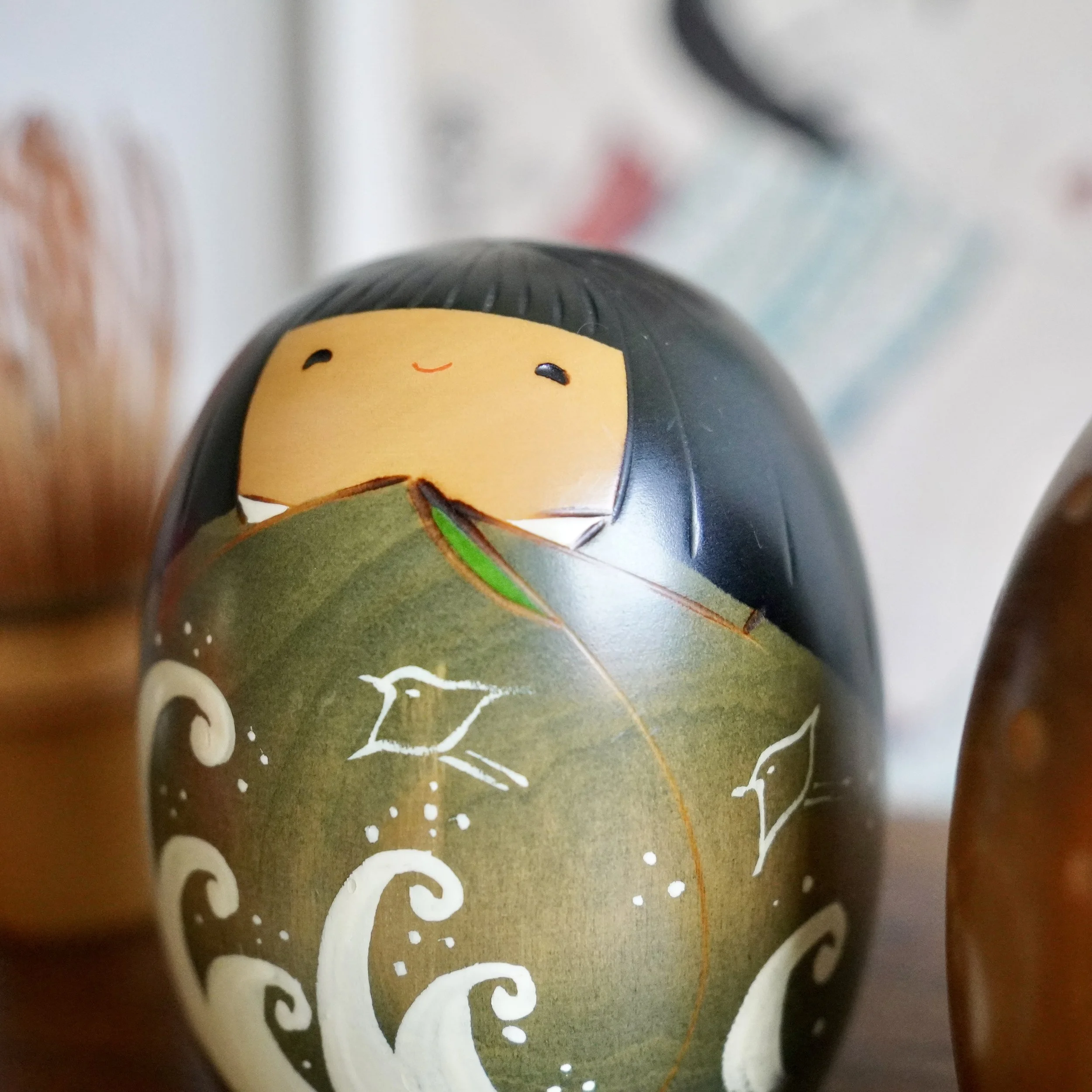 Close up of vintage Usaburo kokeshi summer doll, hand painted wave and bird motif, Shiki no Uta series, Showa period