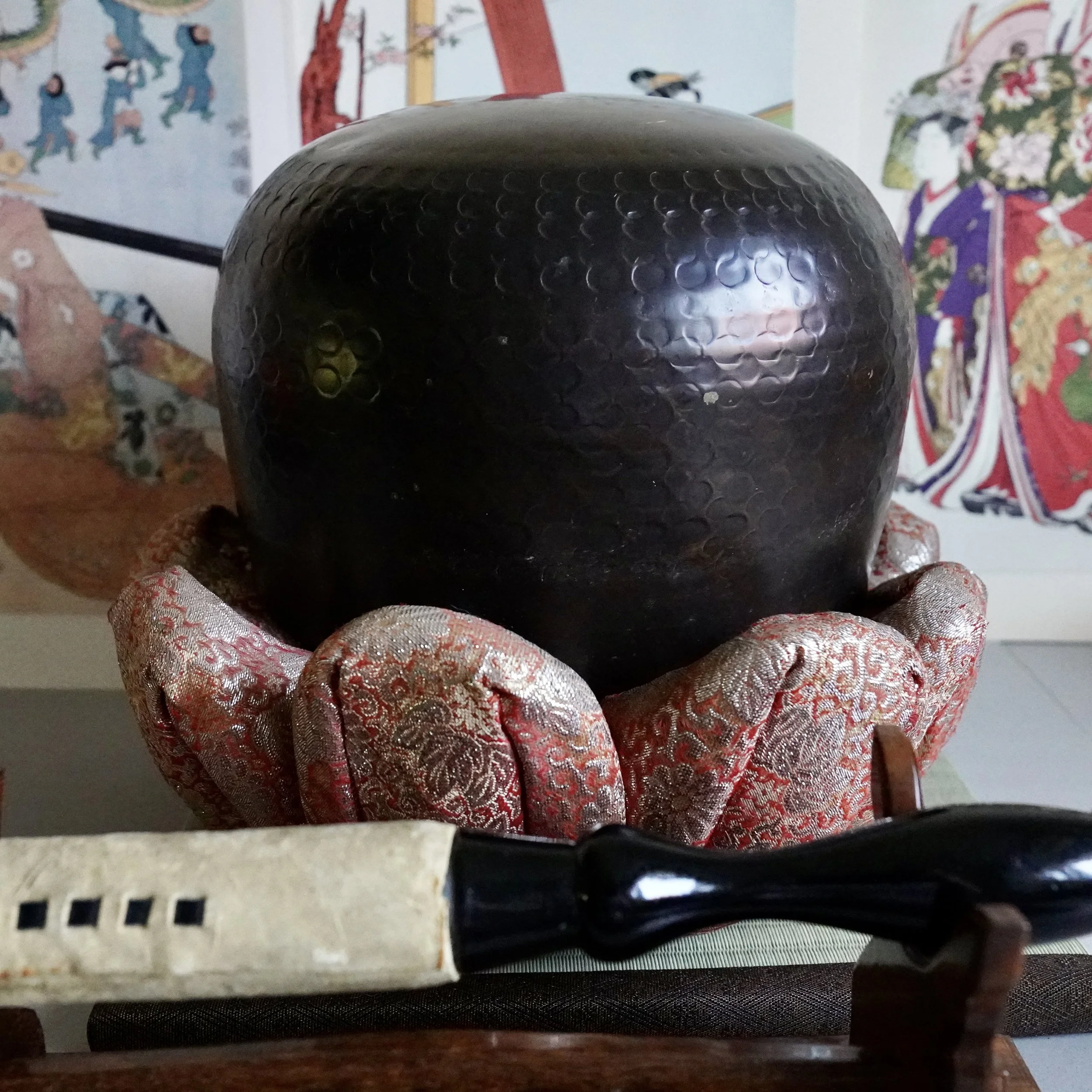 Signed Tsutsumi orin, Japanese bronze singing bowl, with striker resting on tatami mat