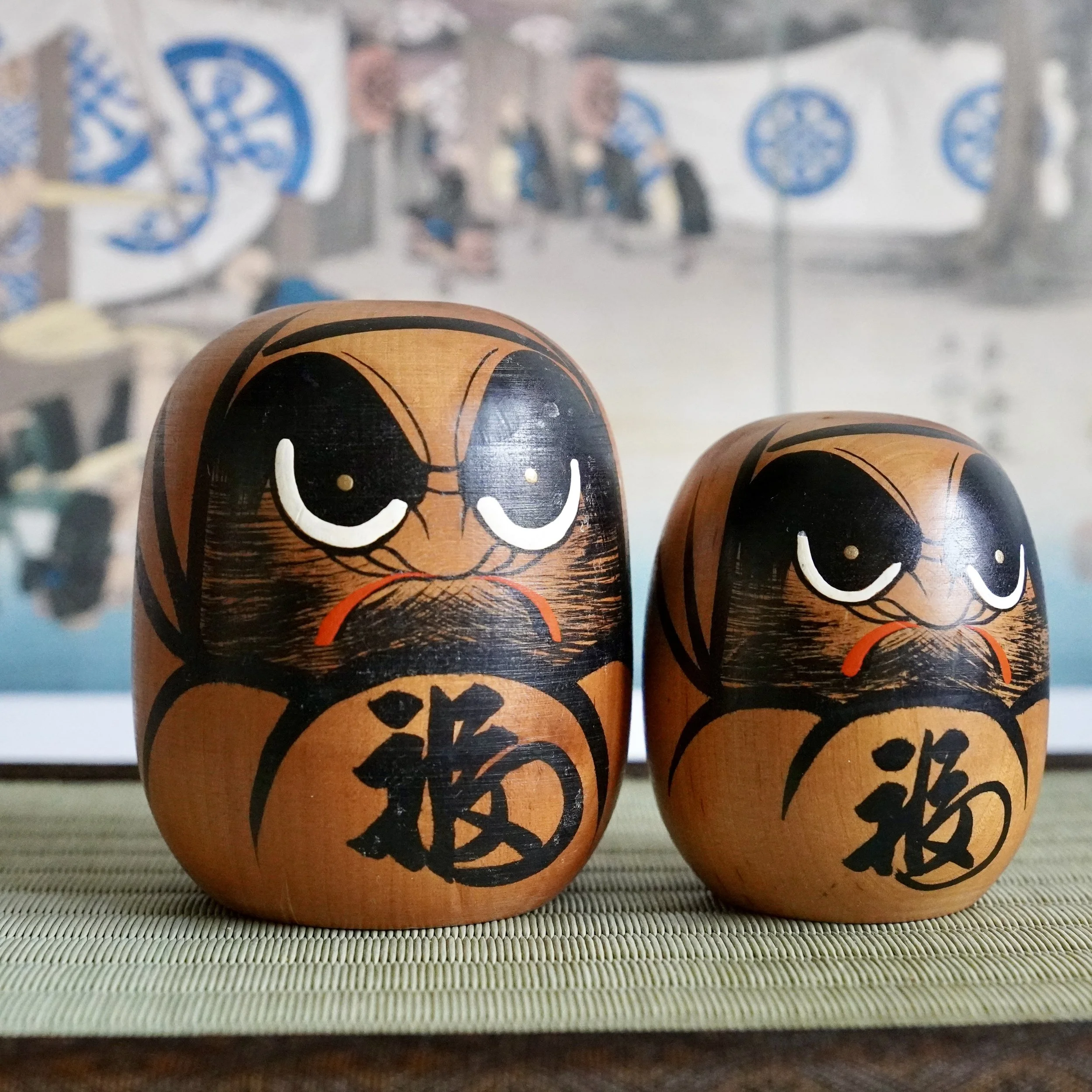 Wooden daruma pair standing together, fuku kanji painted on the belly, Showa period Tohoku craft.