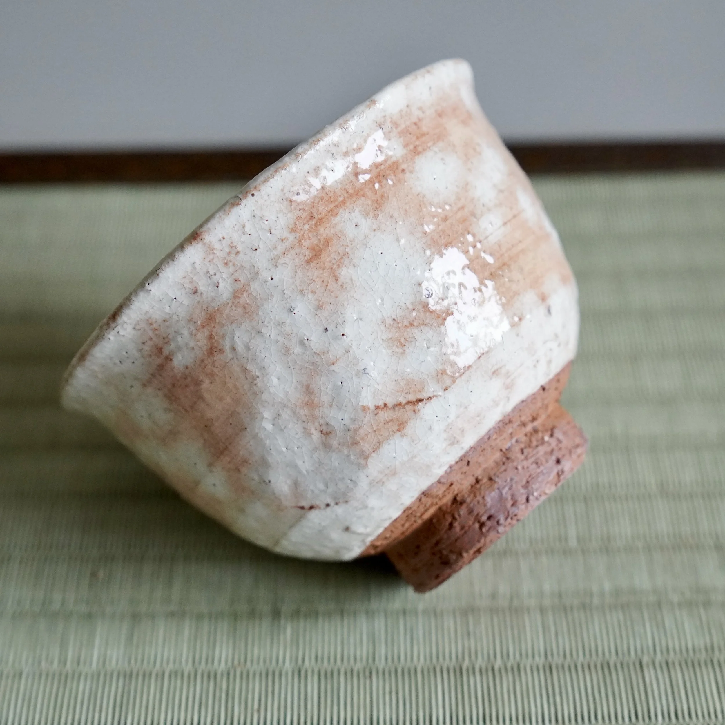Shira-hagi Hagi-yaki yunomi by Taizan kiln, side view showing white glaze pooling in clouds over warm russet clay, characteristic Hagi texture, Japan