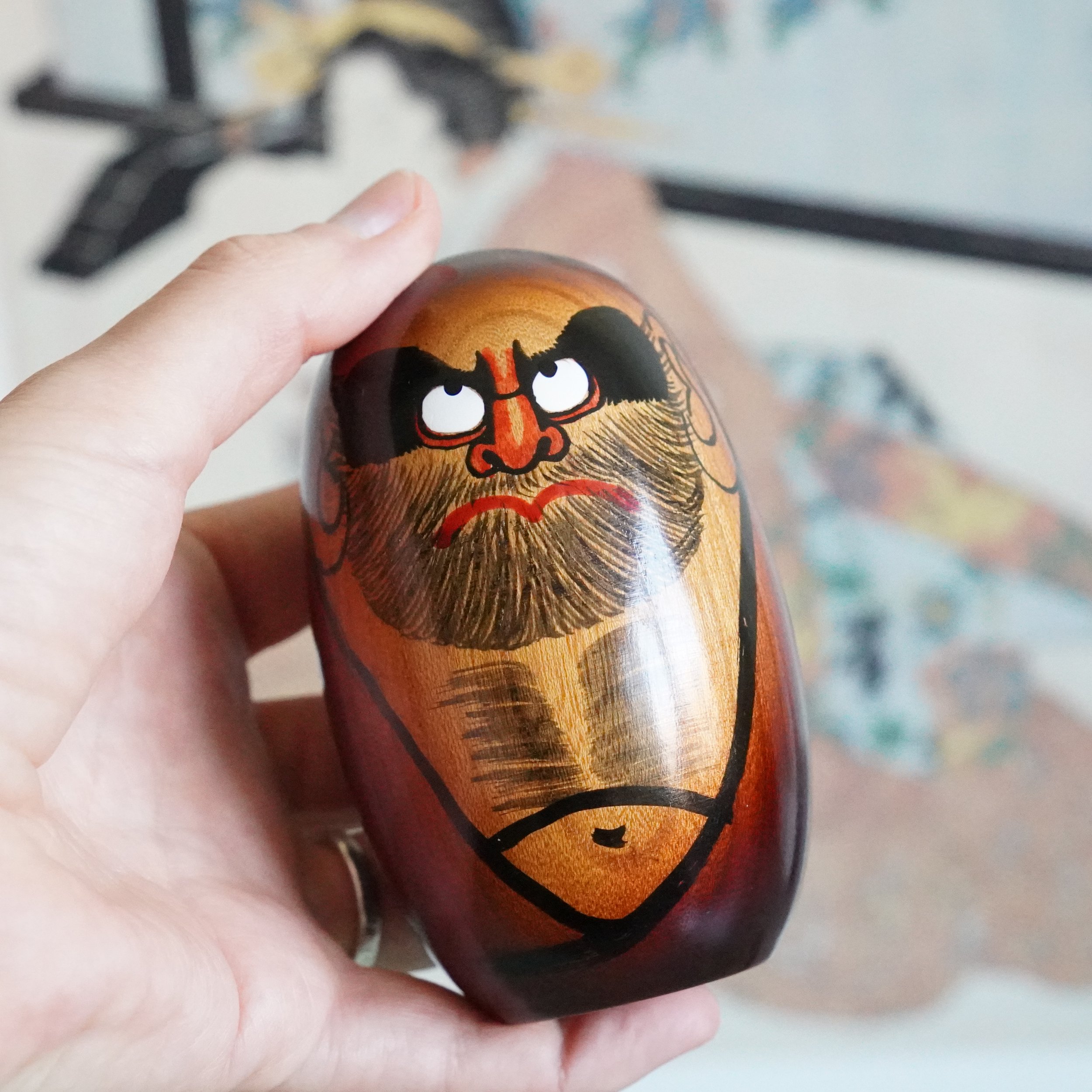 Hand painted Daruma Daishi held in hand, keyaki wood by Seifu Gono