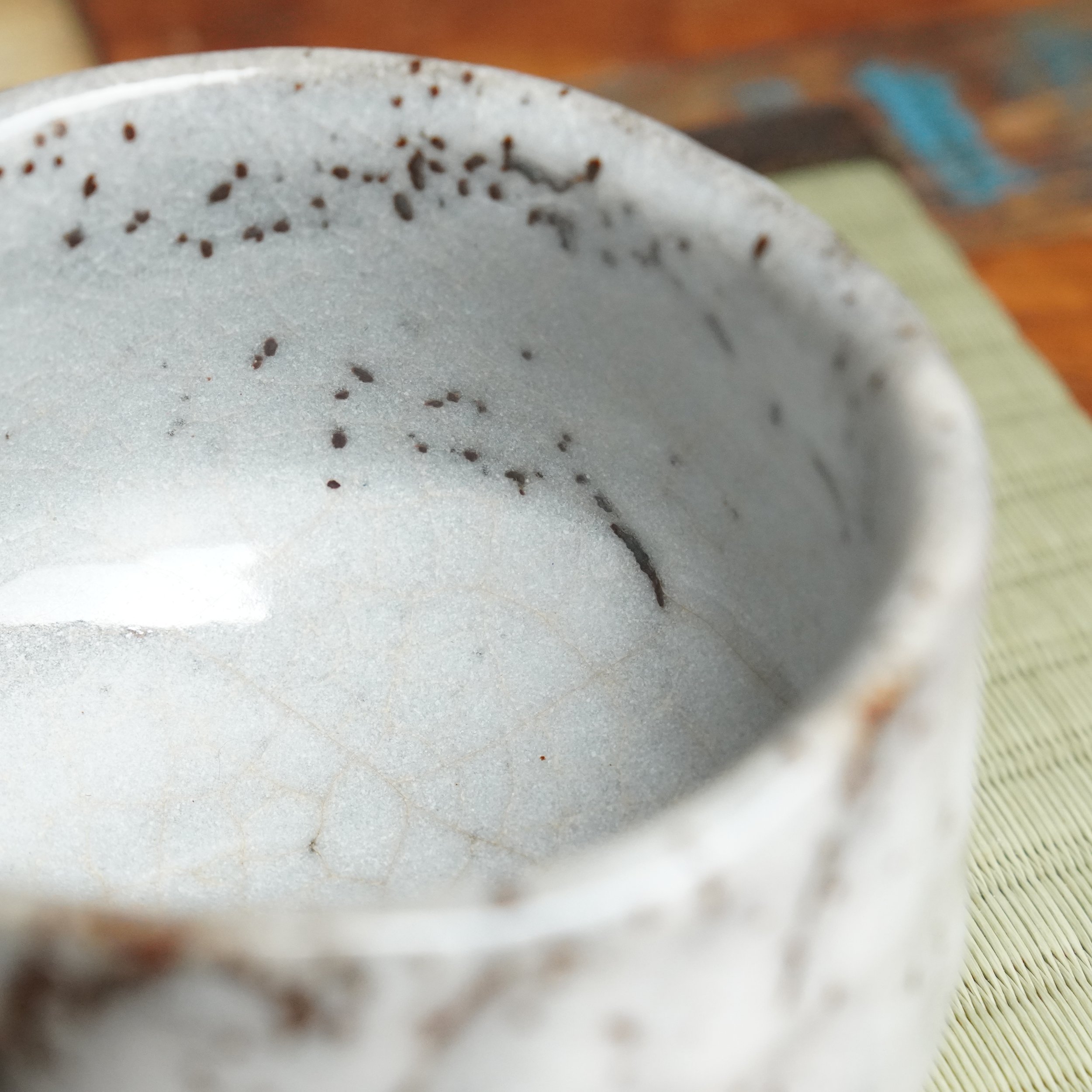 Katō Shōzan Oni-Shino chawan interior with white crazed glaze, detailed with rust brown flecks and drips from the rim.