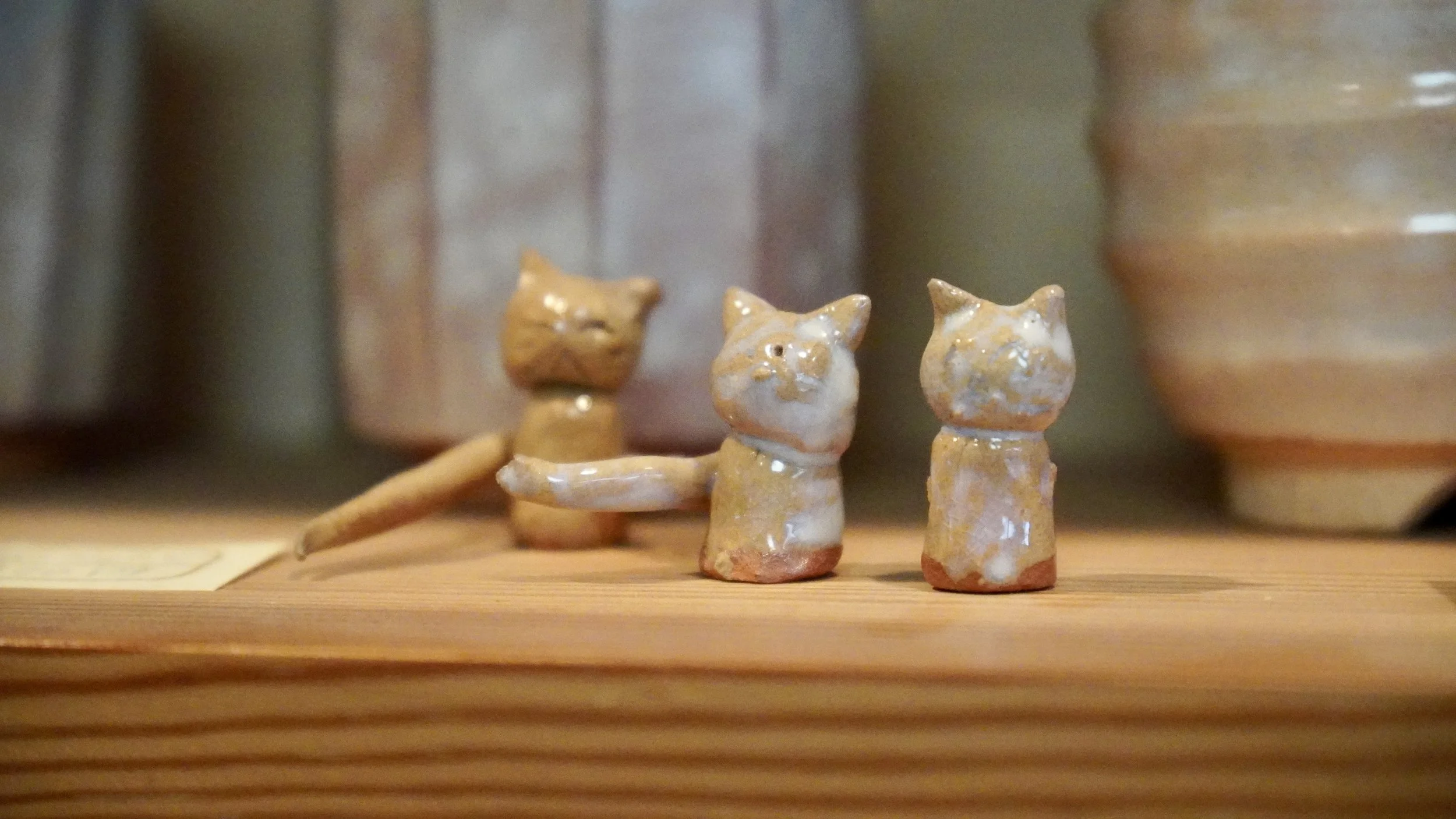 Three small glazed Hagi-yaki cat figurines handmade by a young family member at the Okada kiln, Japan