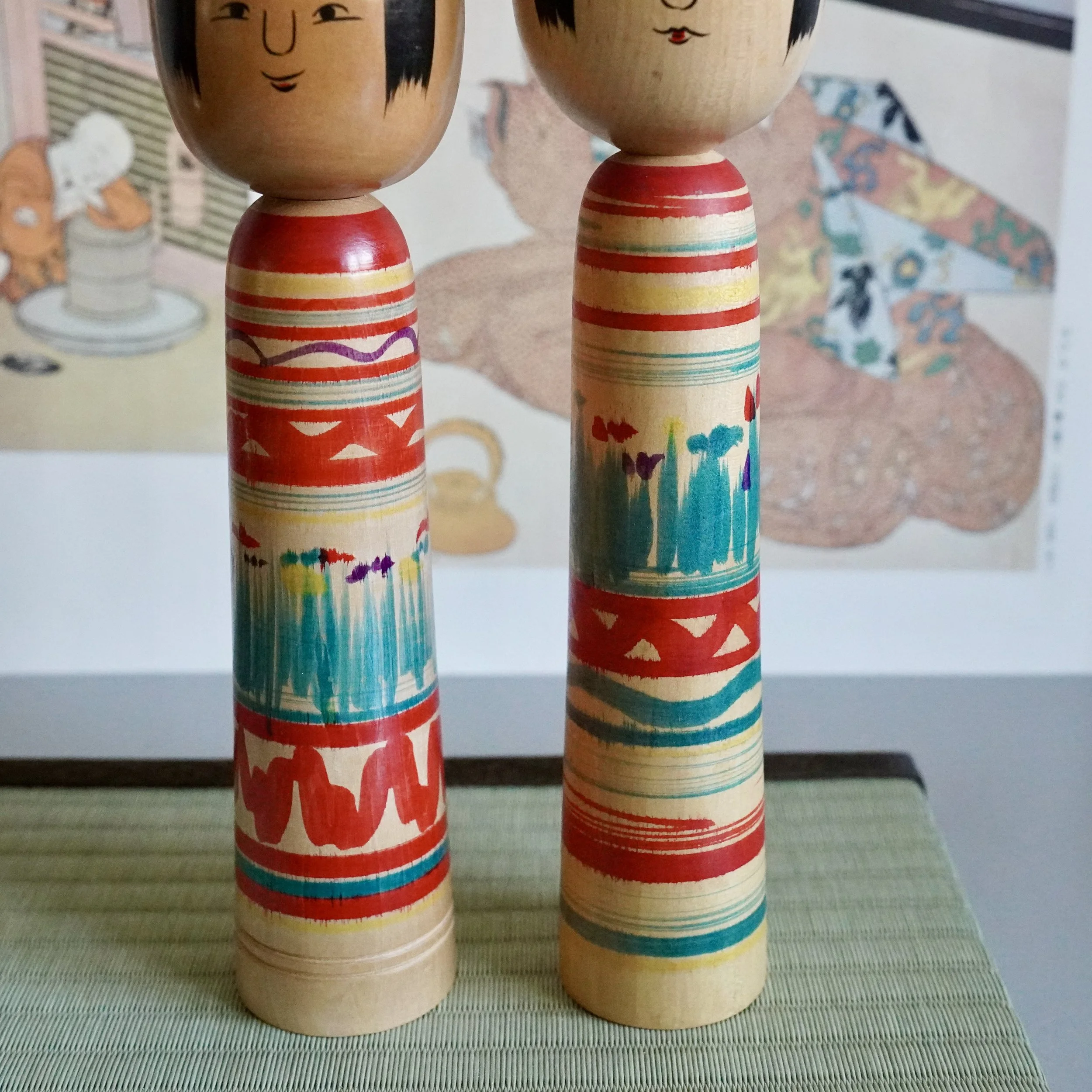 Pair of vintage Tsuchiyu kokeshi dolls with striped bodies, signed Shōwa period wooden dolls.