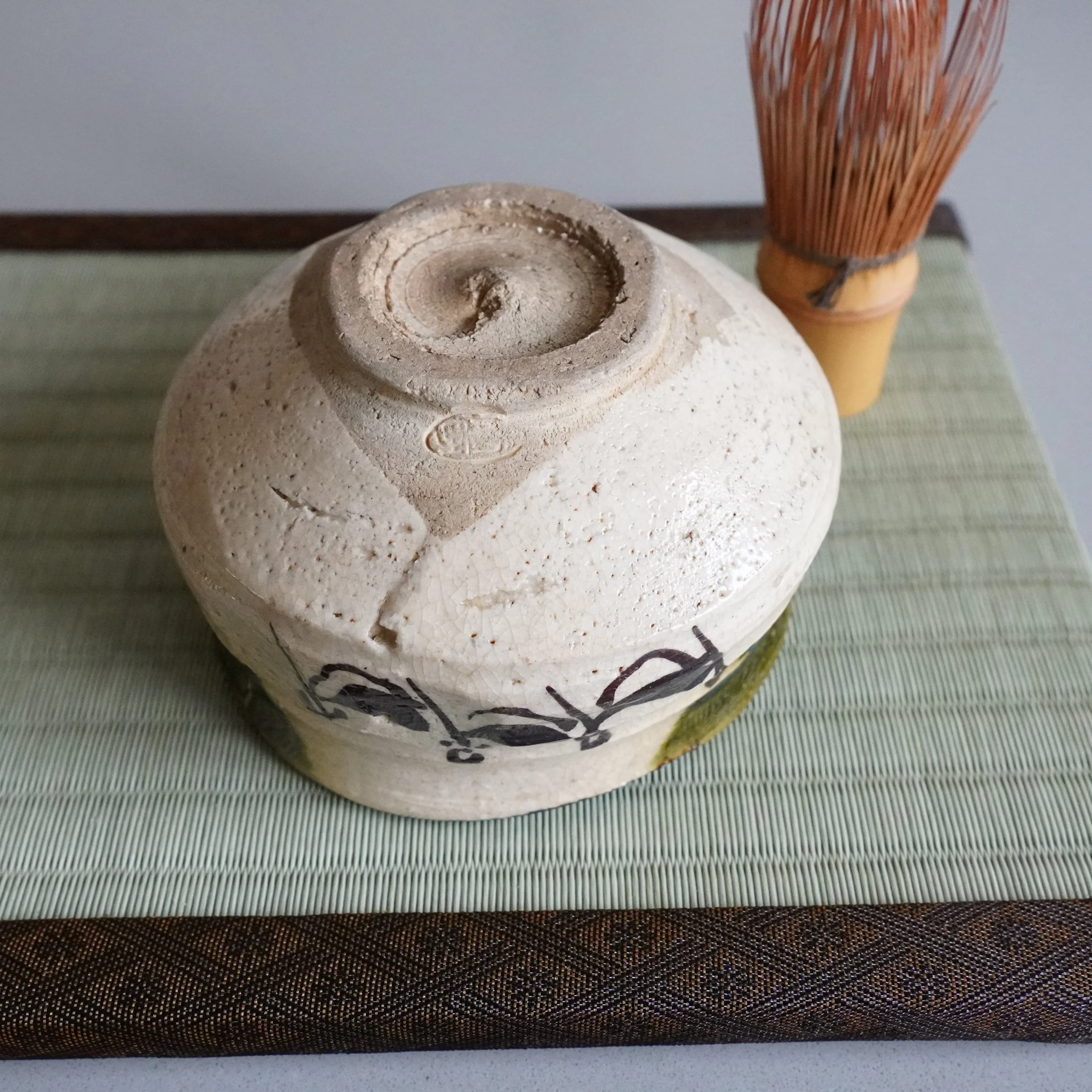 Ao-Oribe matcha bowl with vintage bamboo chasen on tatami scale shot Mino ware stoneware iron brushwork figures and vine scroll decoration Showa period Japanese tea ceremony set