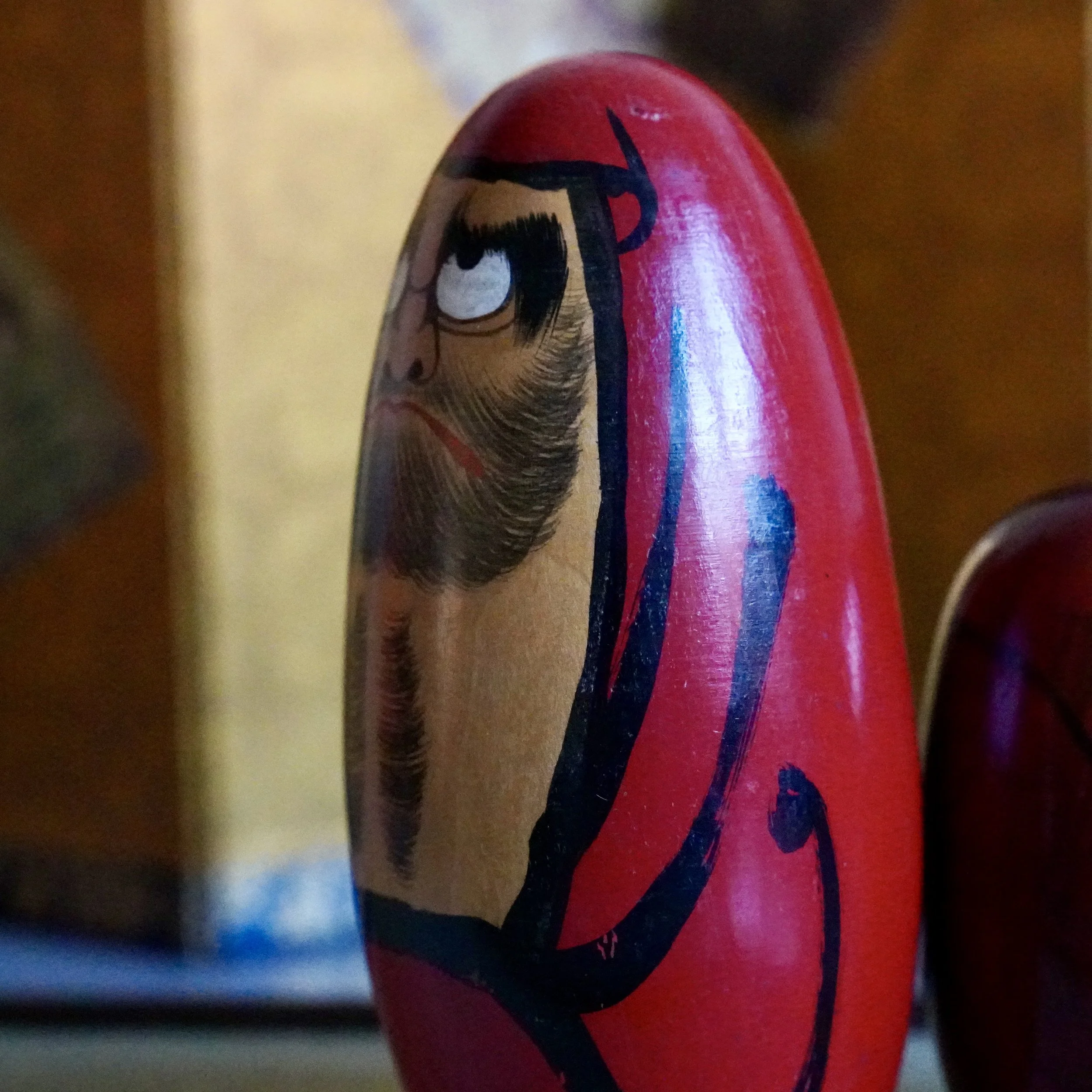 Vintage daruma side profile by Shido Shozan, Shōwa period, vermilion lacquer