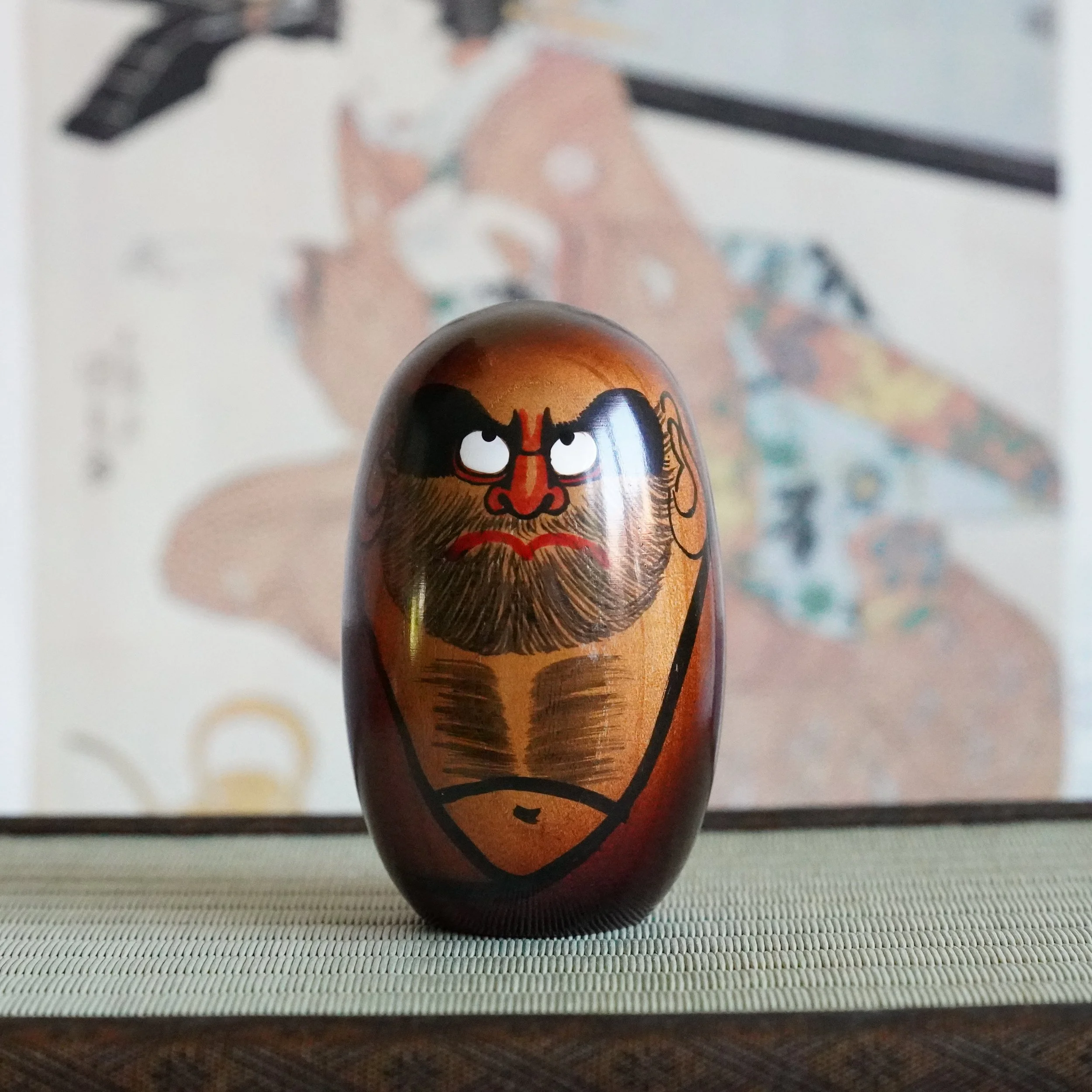 Hand painted Daruma Daishi figure in keyaki wood by Seifu Gono, black brows and red nose