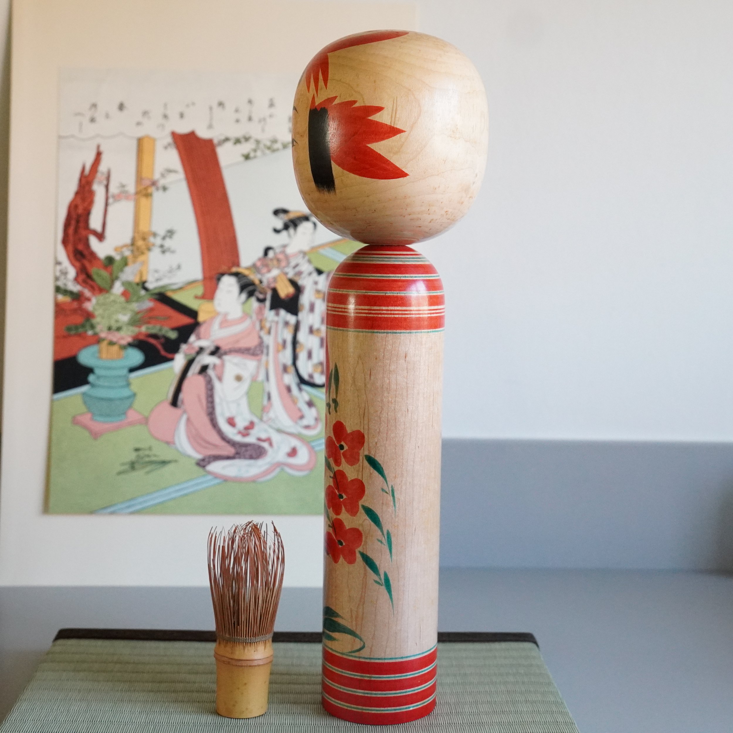 Traditional Yamagata kokeshi by Takasaki Eiichirō, three-quarter rear view, natural wood grain visible, ukiyo-e print in background, Shōwa period