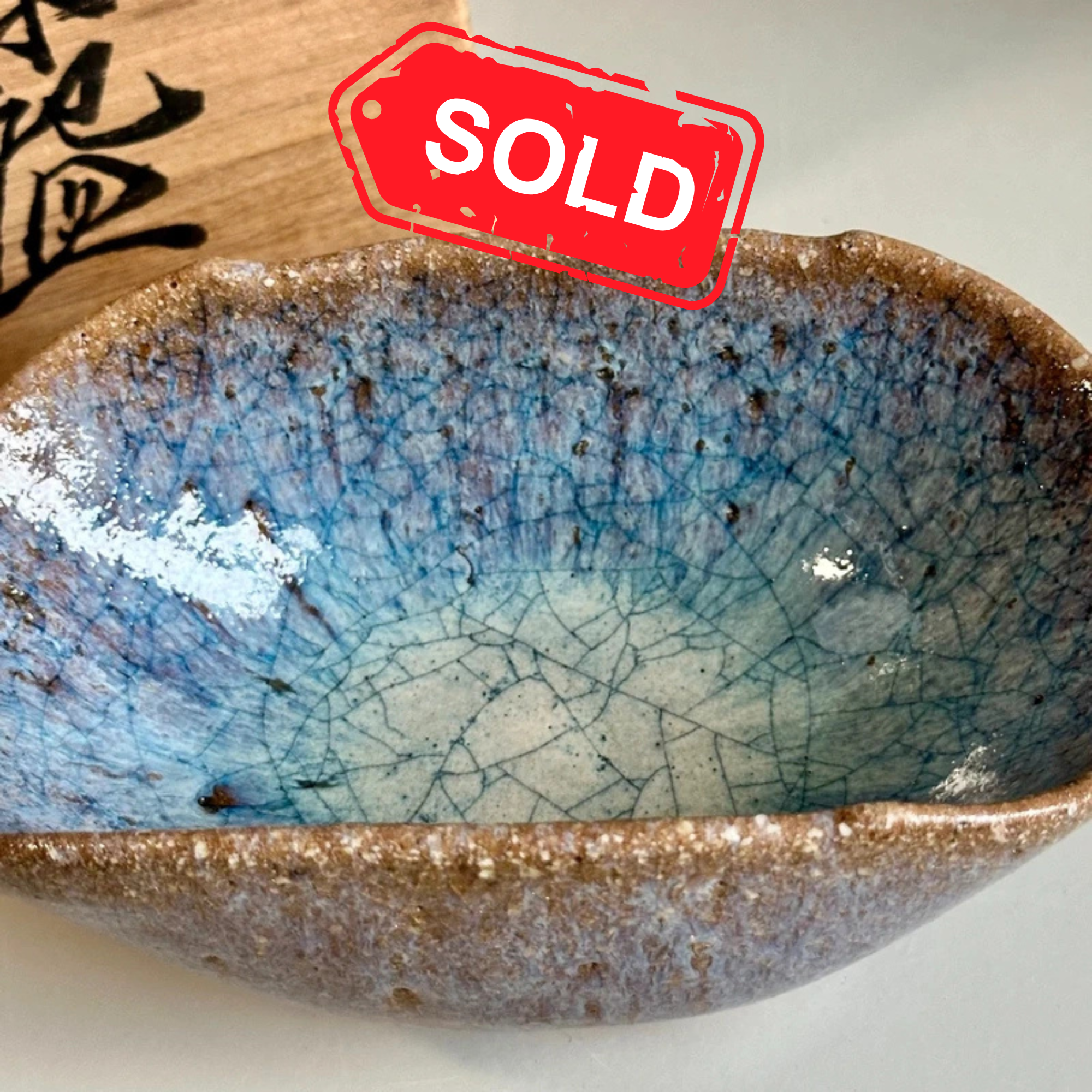 Kyo-yaki chawan with yōhen glaze by Uno Tōru, signed, shown from above next to original tomobako, late Shōwa, interior view