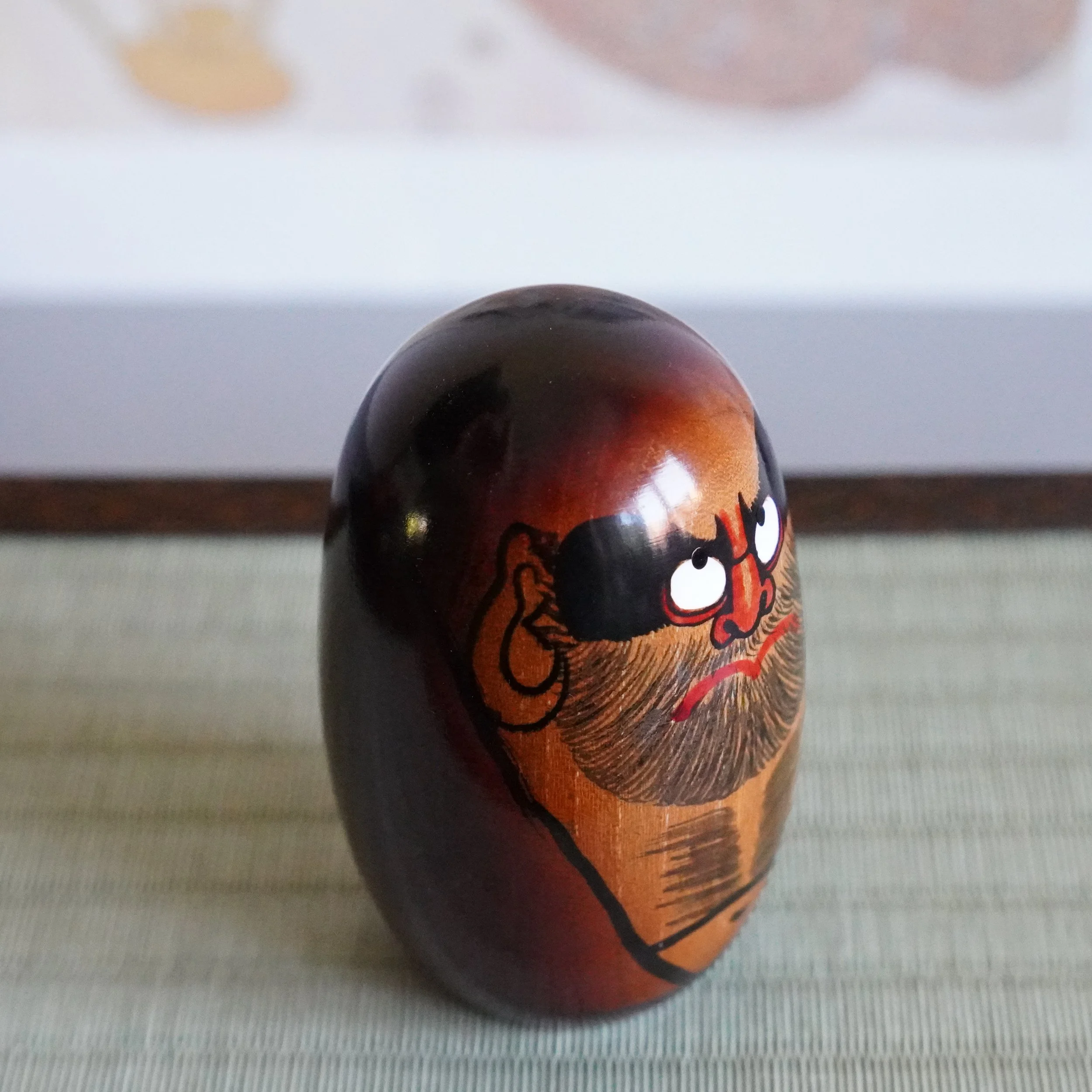 Hand painted Daruma Daishi face by Seifu Gono, black brows and red nose, keyaki wood