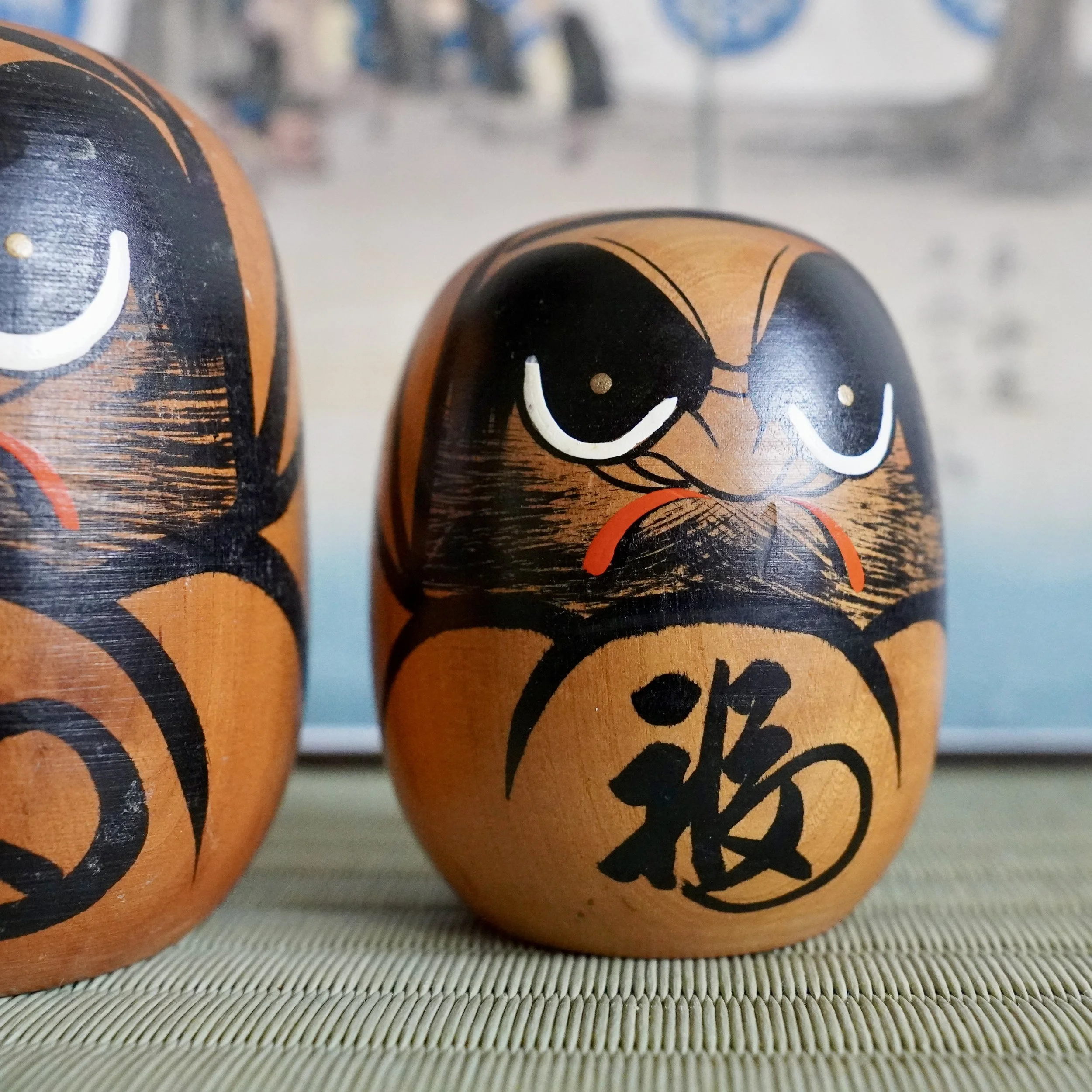 Close up of a hand painted daruma face, fuku kanji visible, vintage Tohoku turned wood craft.
