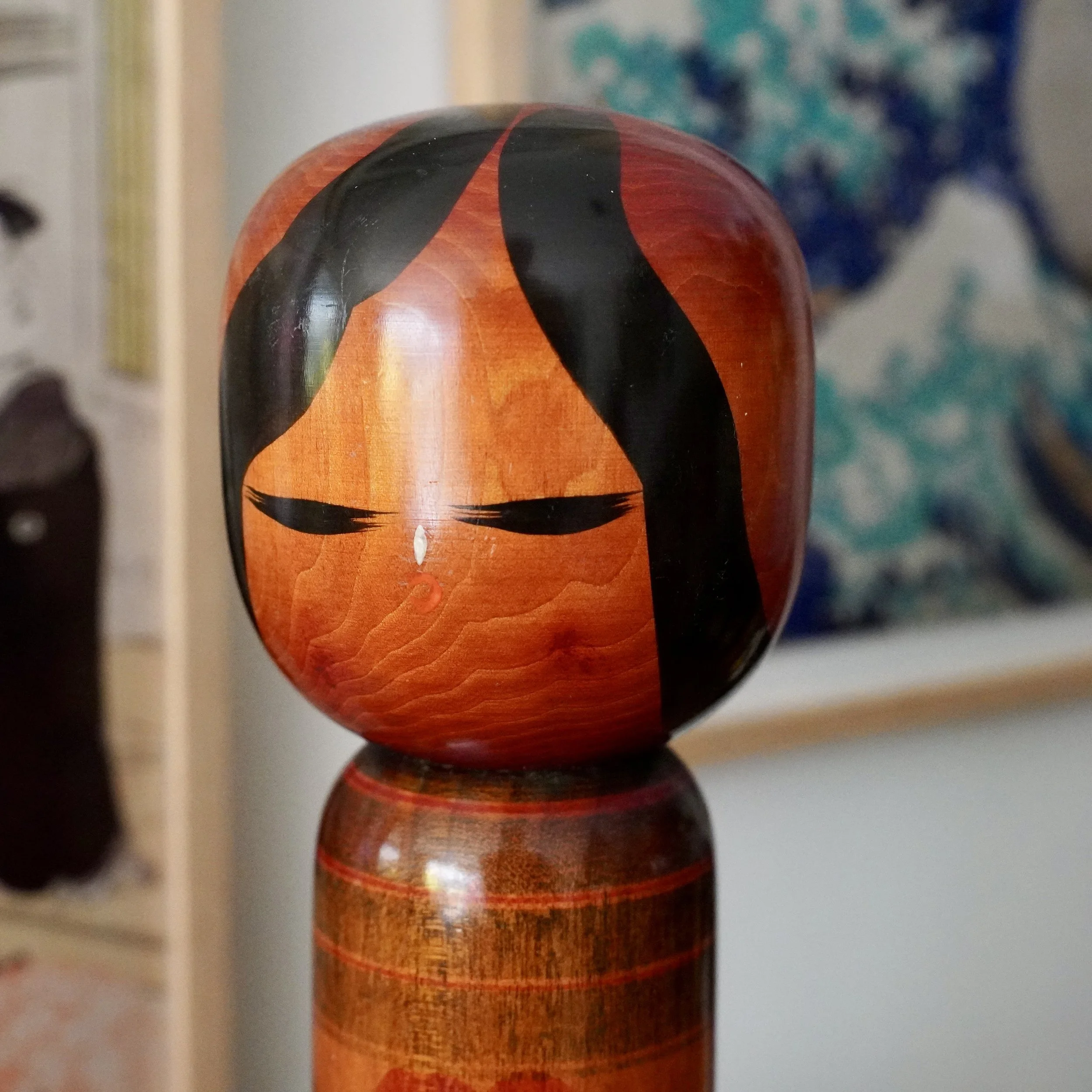 Close-up of camellia girl kokeshi face, black hair detail