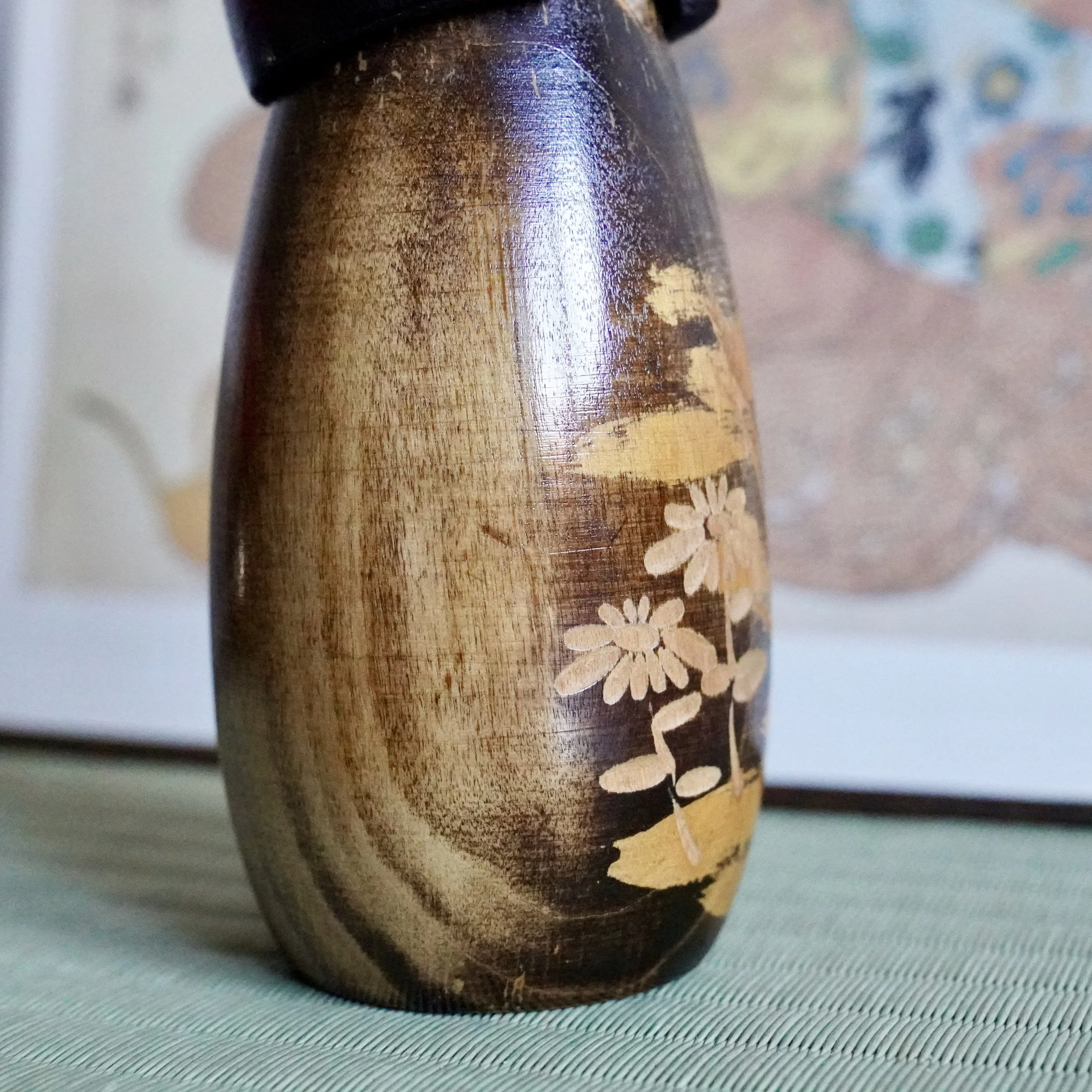 Carved chrysanthemum relief detail, natural wood tone against lacquer