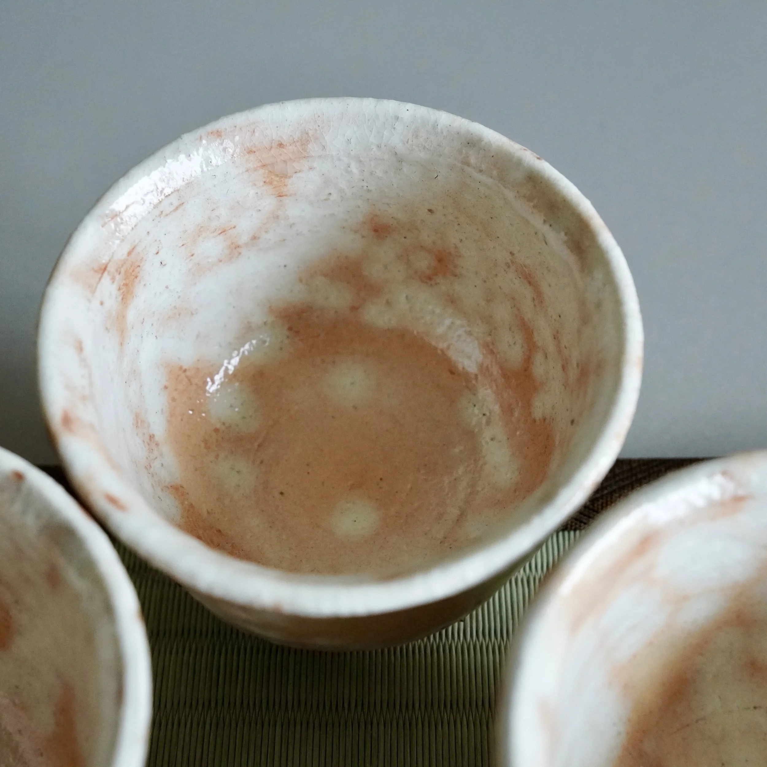 Interior view of shira-hagi Hagi-yaki yunomi by Taizan kiln, white and russet glaze with soft sheen and fine crazing, warm terracotta clay visible at rim, Japan