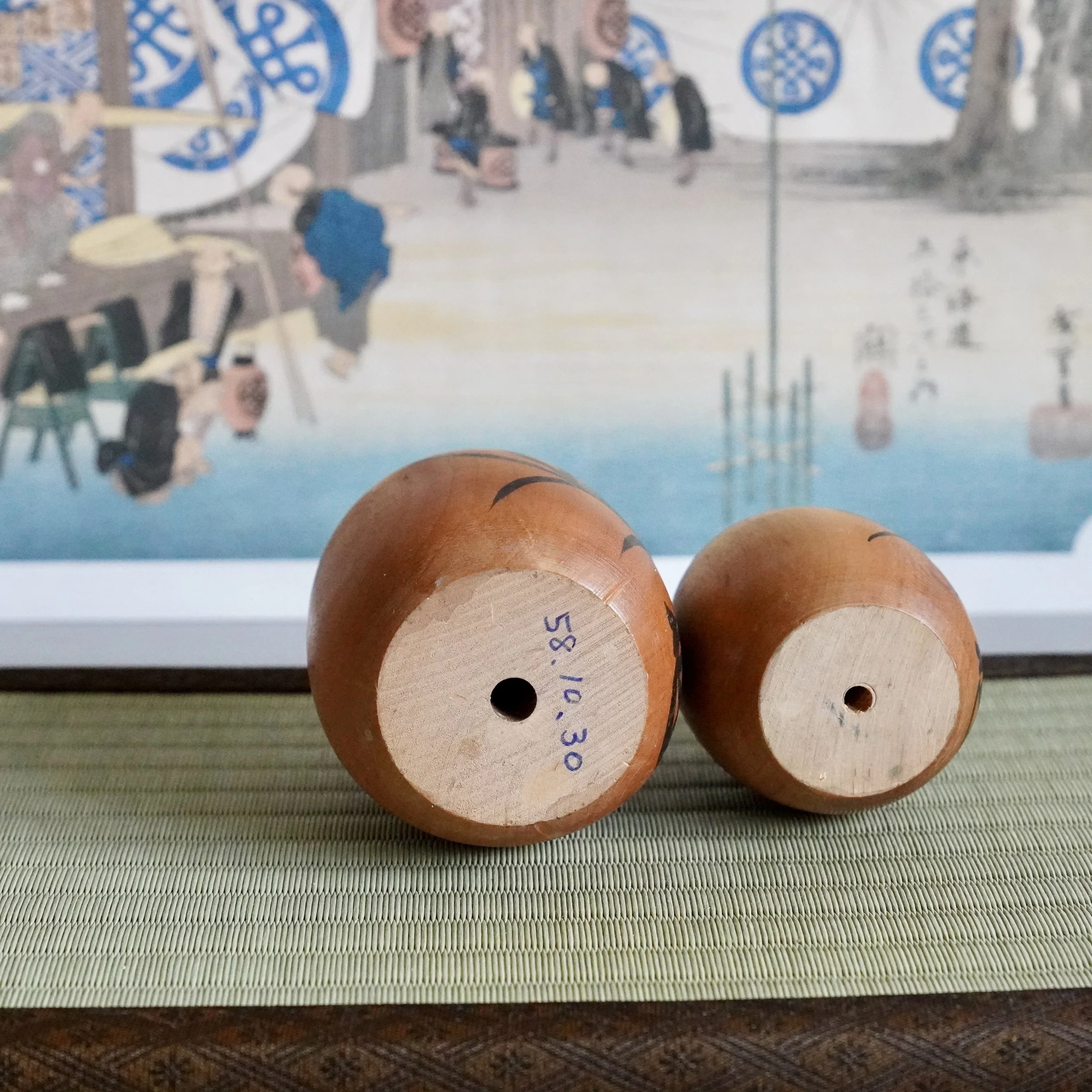 Underside of a vintage wooden daruma pair showing a handwritten Showa era date mark on the base.