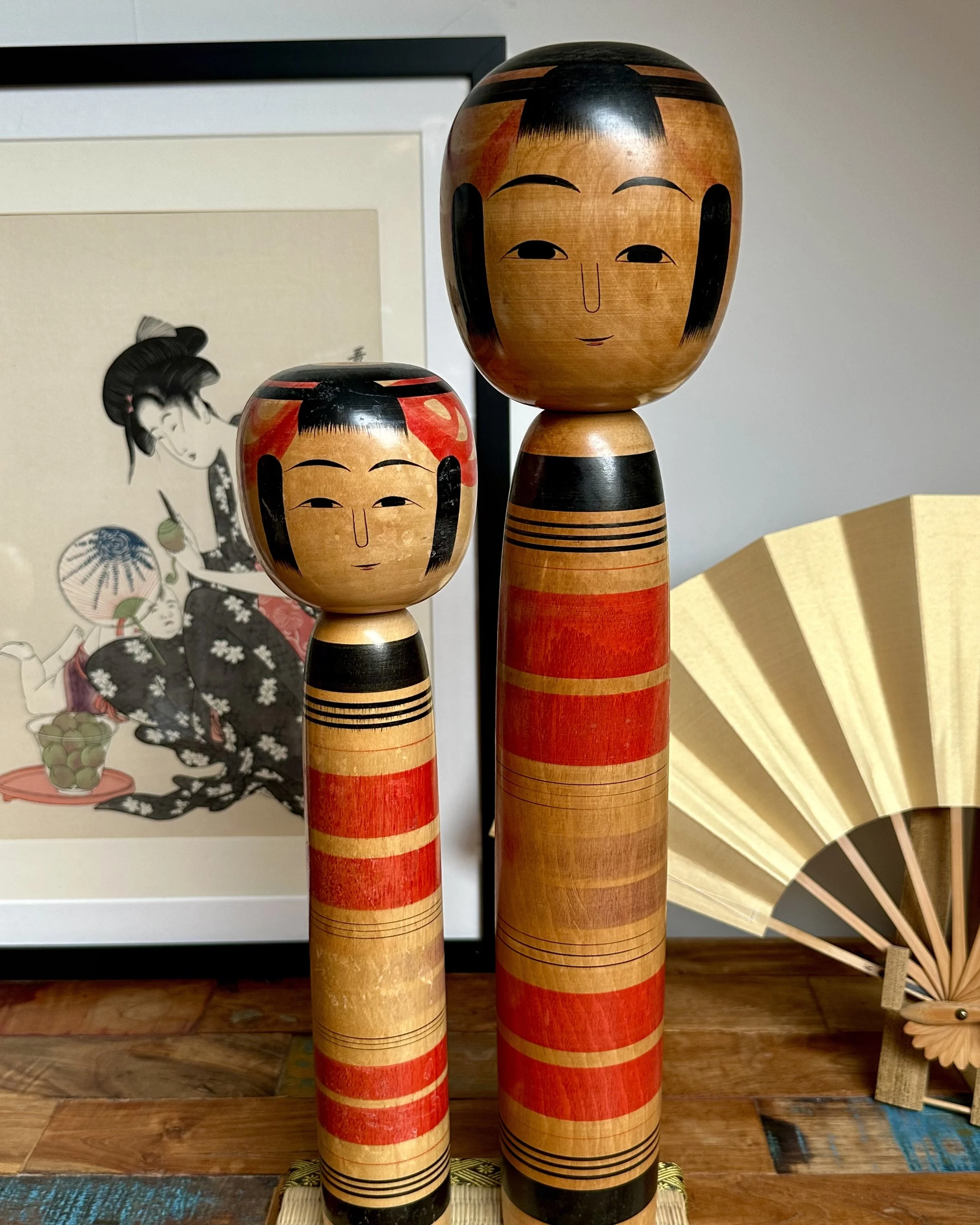 Pair of large Tsuchiyu kokeshi by Abe Ichirō, 46.5 cm and 36 cm, red and black banding, signed, Shōwa period ca. 1970s