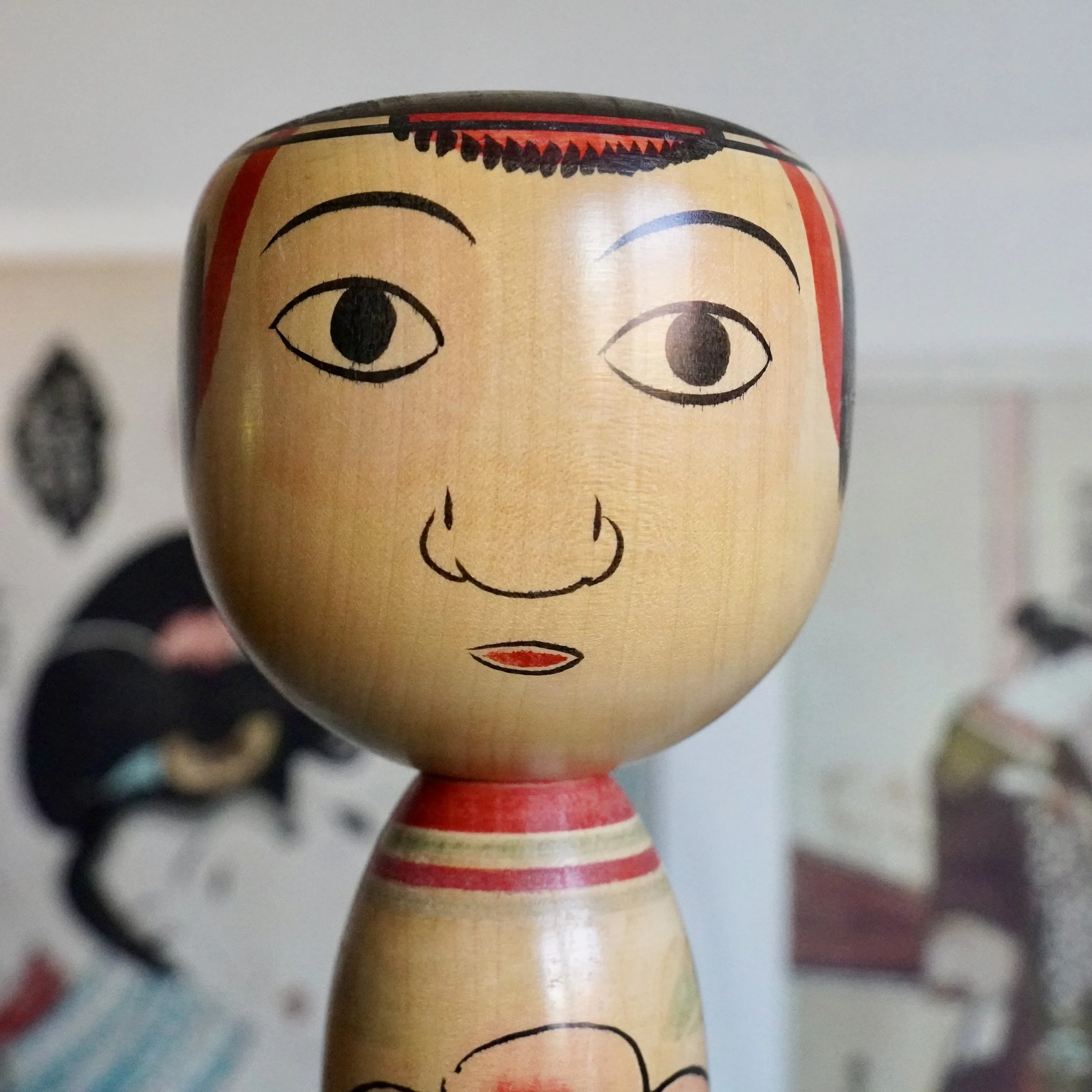 Close up of a single Nakanosawa Takobozu kokeshi head, painted face, signed vintage kokeshi by Saito Tokuju
