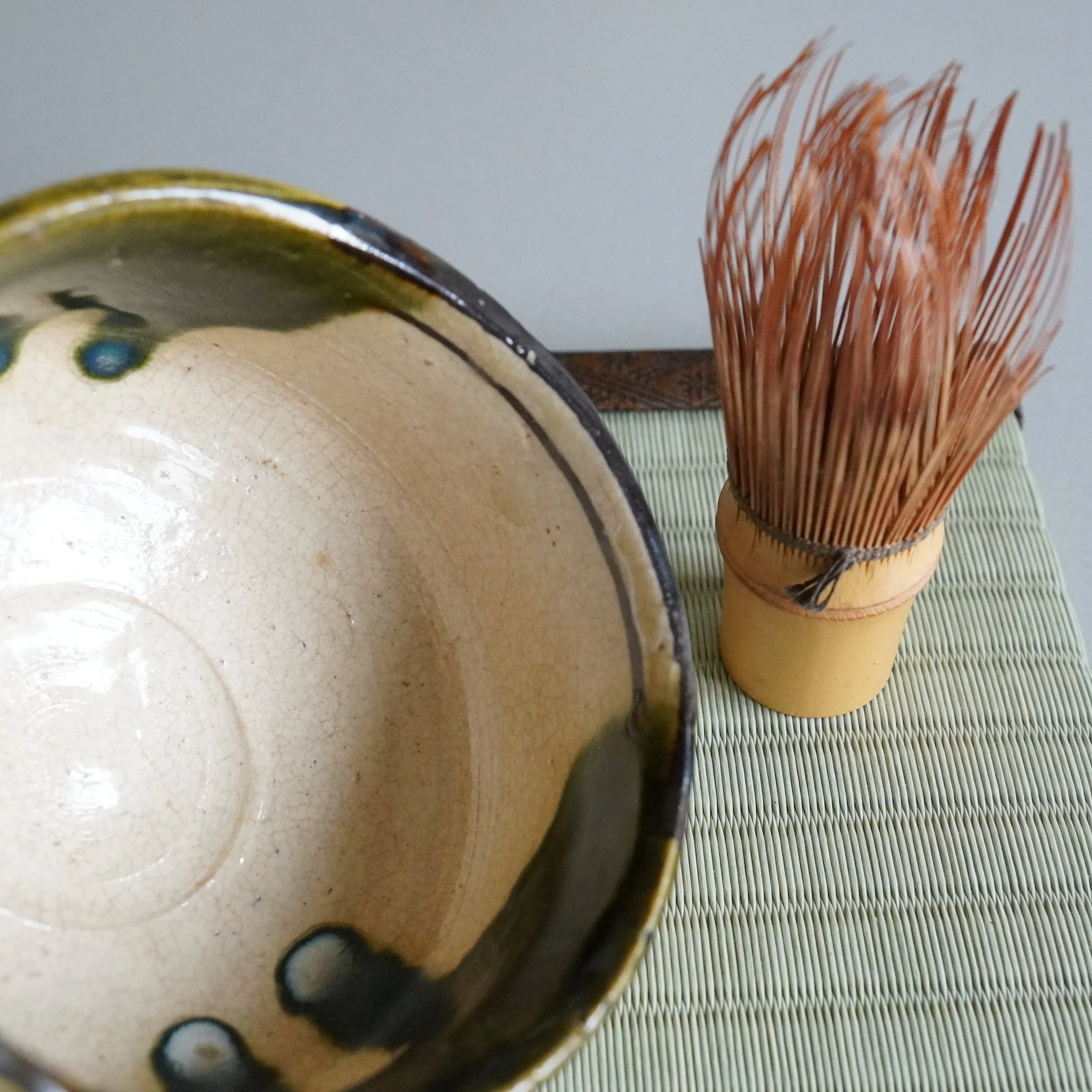 Ao-Oribe matcha bowl overhead view with vintage bamboo chasen alongside sandy unglazed exterior foot Mino ware Japanese tea ceremony stoneware Showa period