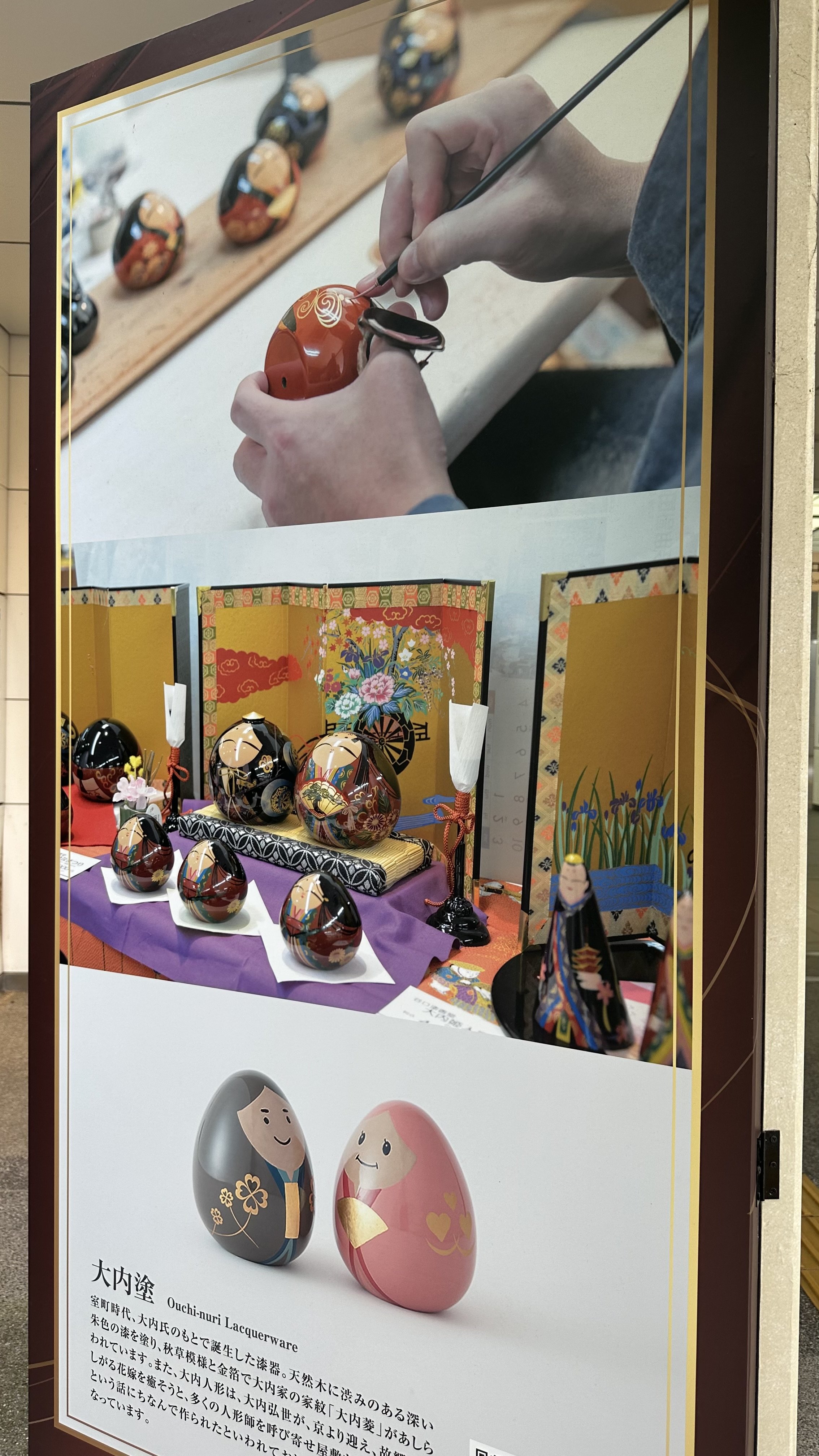Ouchi-nuri craftsman hand-painting gold lacquer on a doll, Yamaguchi station display