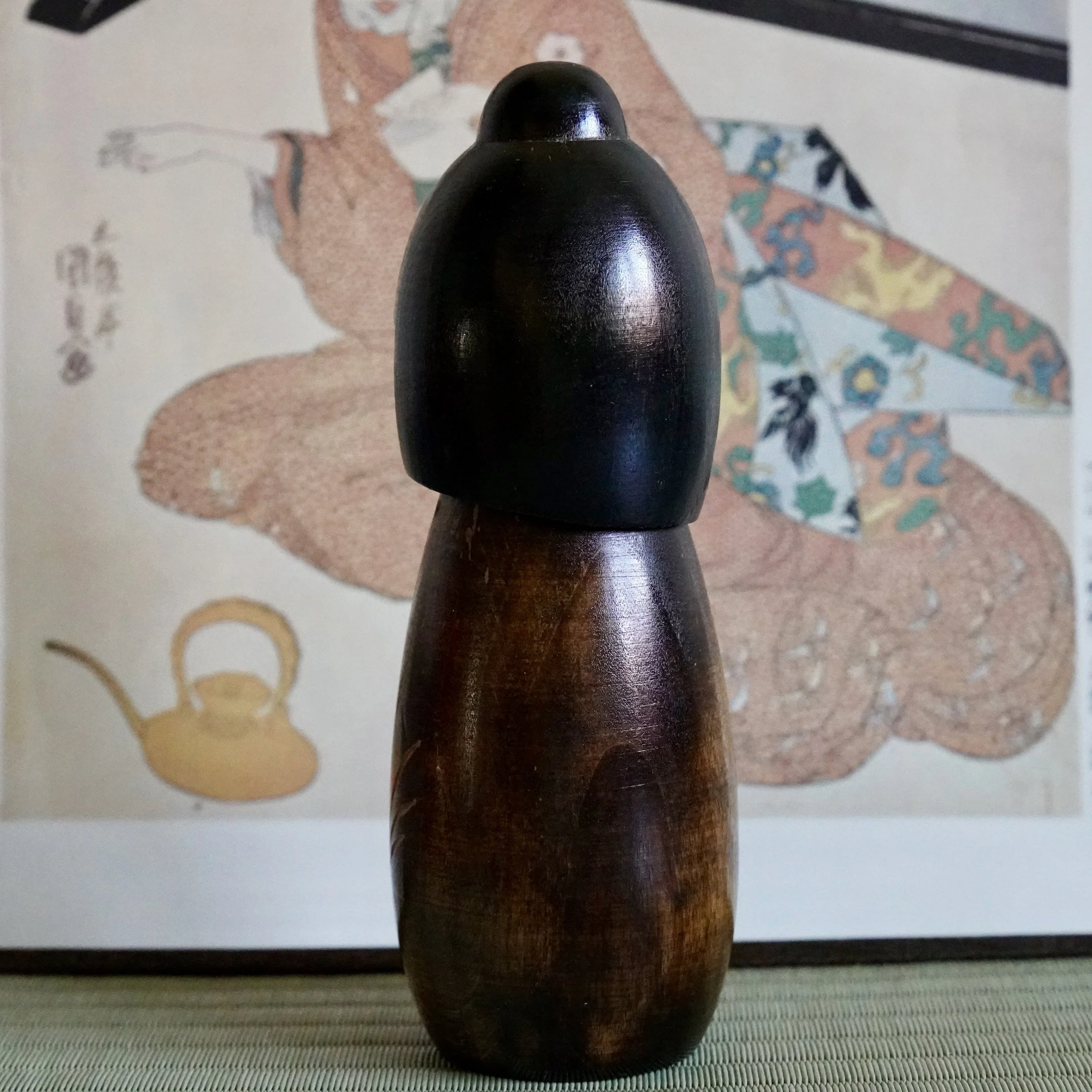 Kokeshi doll back angle showing lacquered wood grain