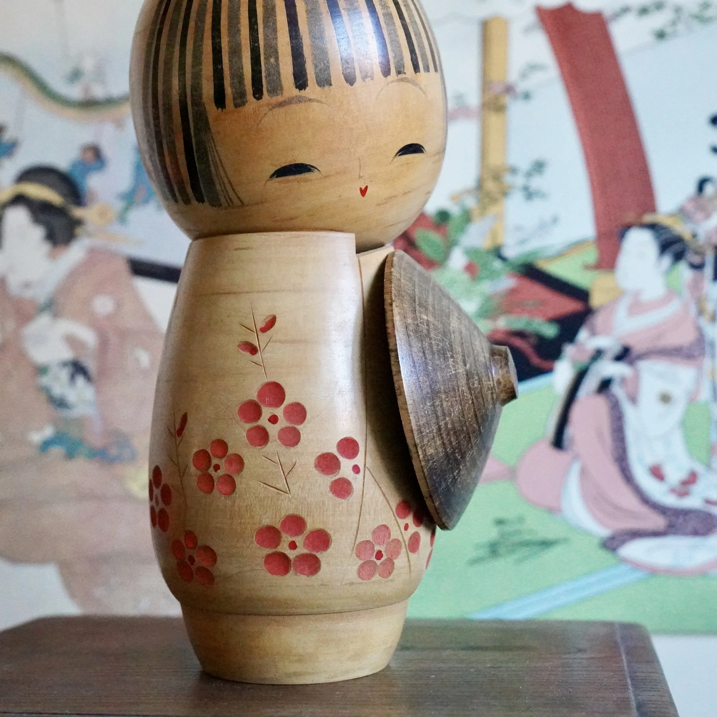 Detail of wooden kasa travel hat joined to Sato Suigai kokeshi, oshinobi dōchū motif