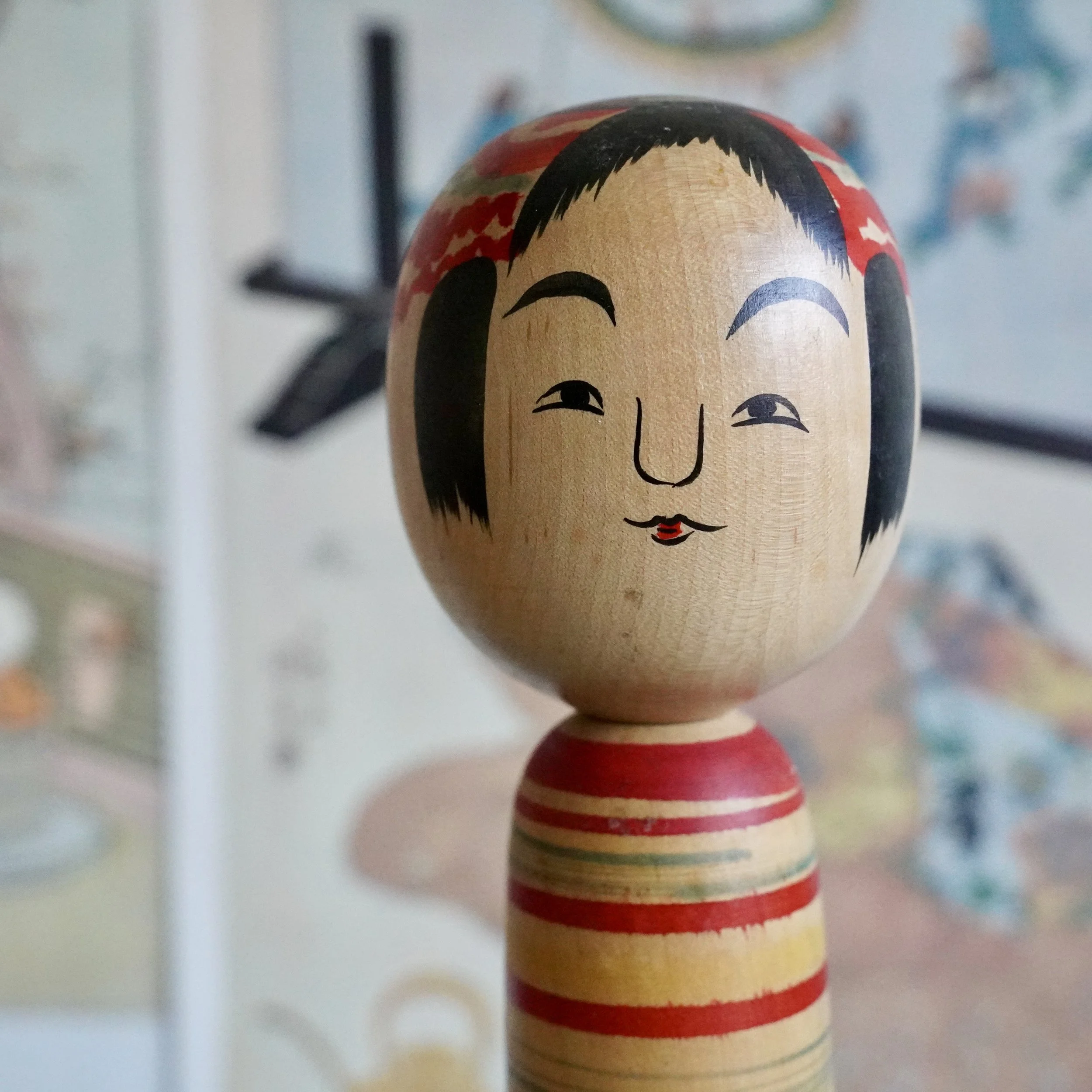 Close-up of a vintage Tsuchiyu kokeshi doll face, small pursed mouth, hand painted by Jinnohara Kazunori.