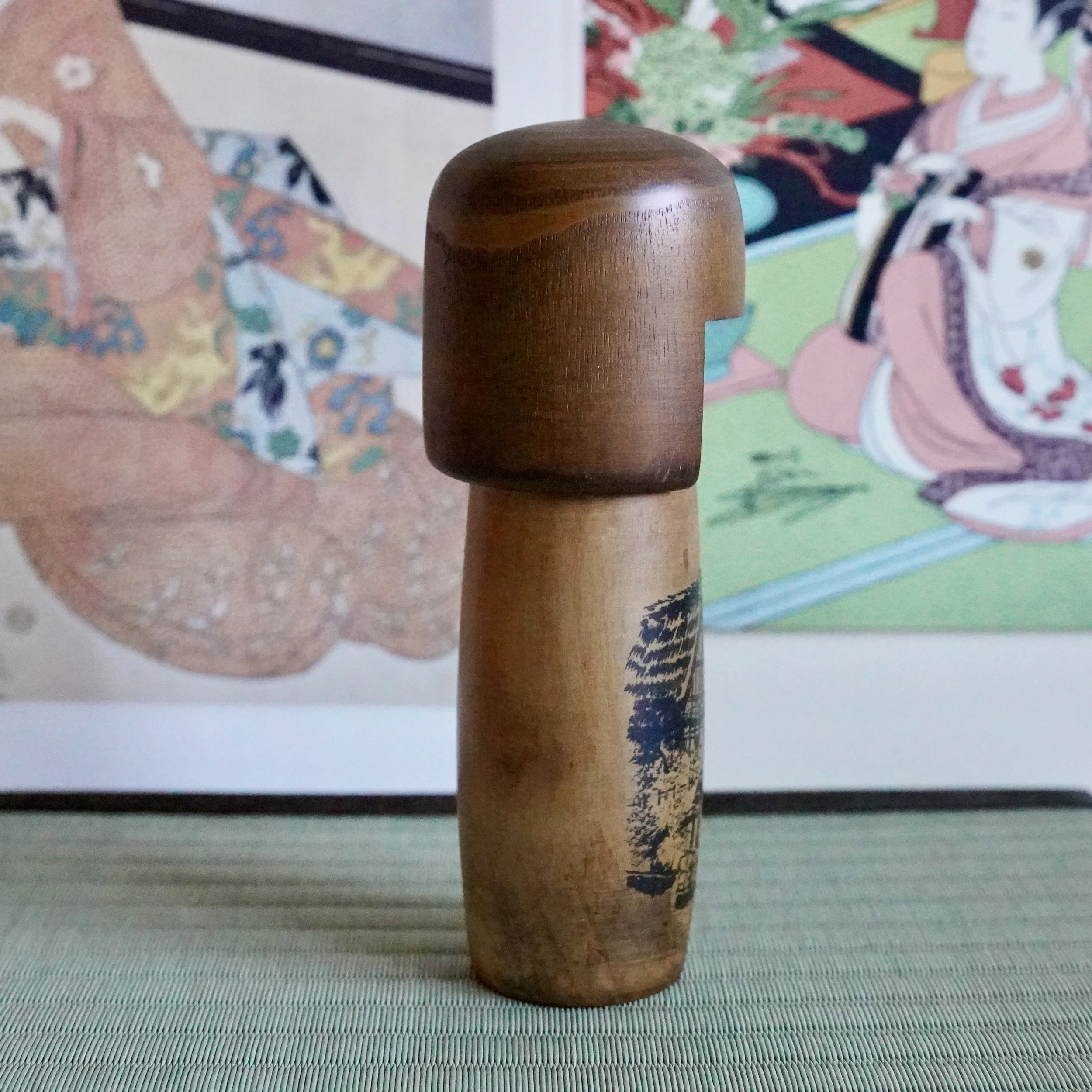 Side view of Usaburō sōsaku kokeshi doll with painted Hida road scene