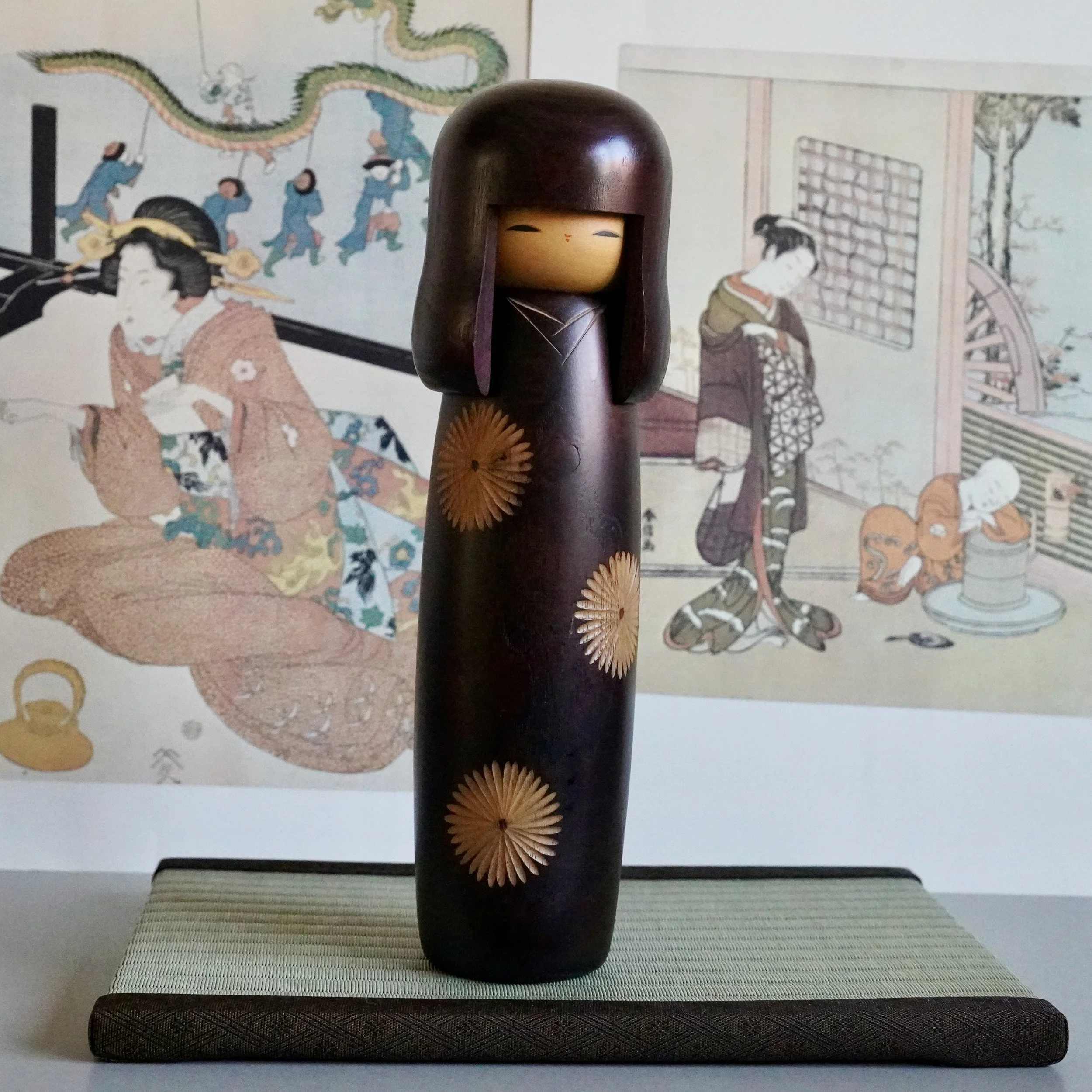 Usaburo sosaku kokeshi doll, dark stained wood, chrysanthemum inlay, full figure front view, Showa period Japan