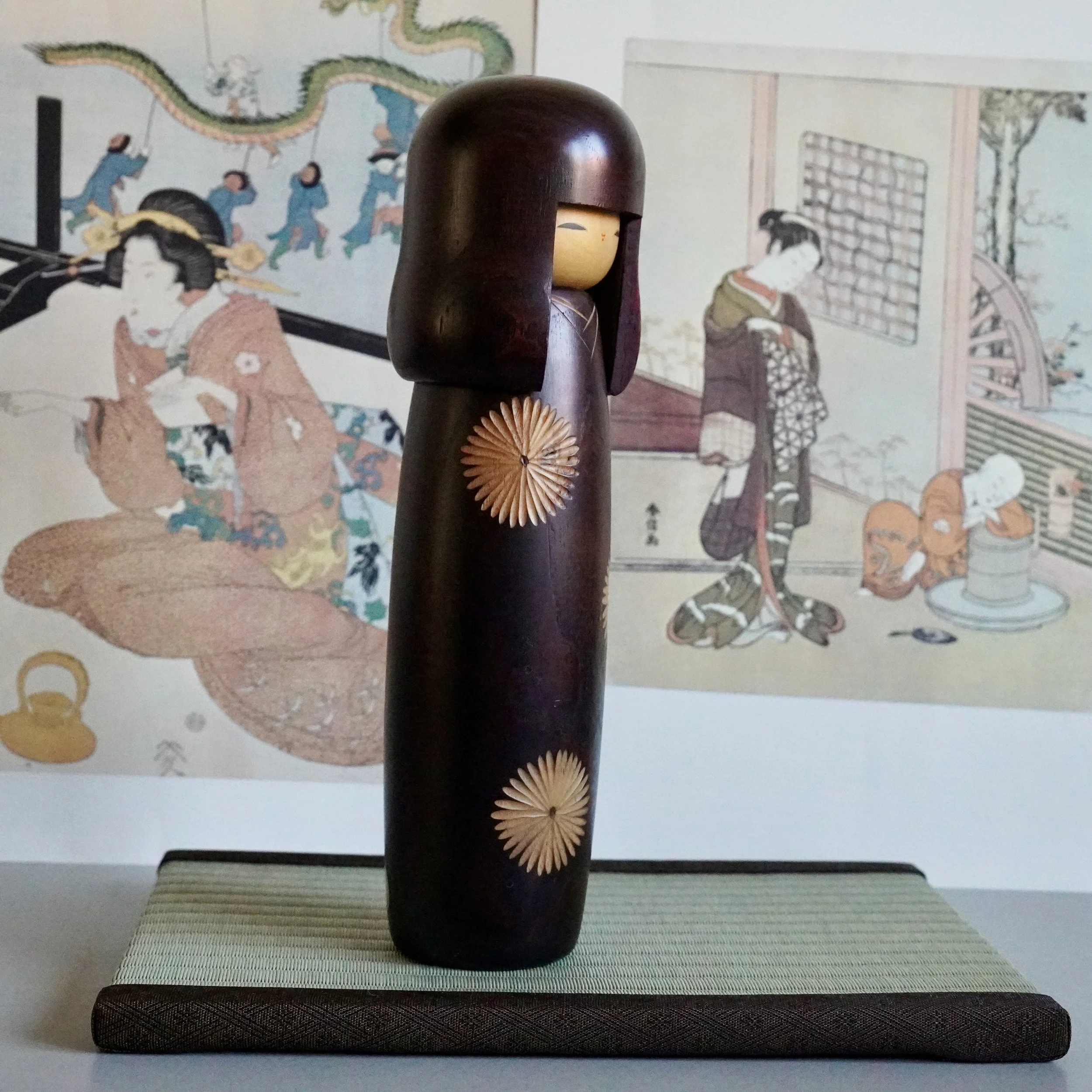 Sosaku kokeshi side view, two chrysanthemum wood inlay medallions on dark stained body