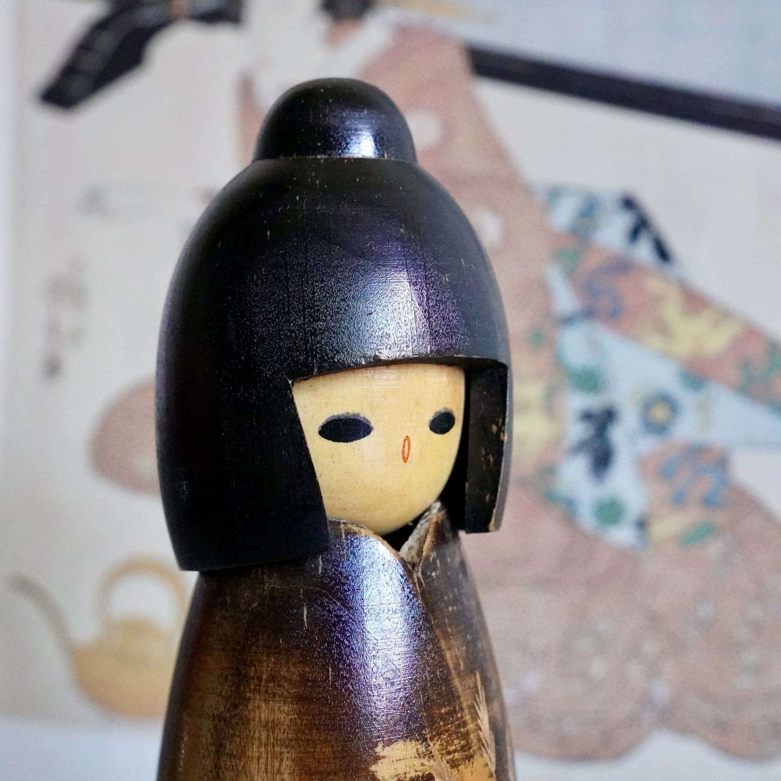 Kokeshi facial features close up, dark lacquer, Shōwa era