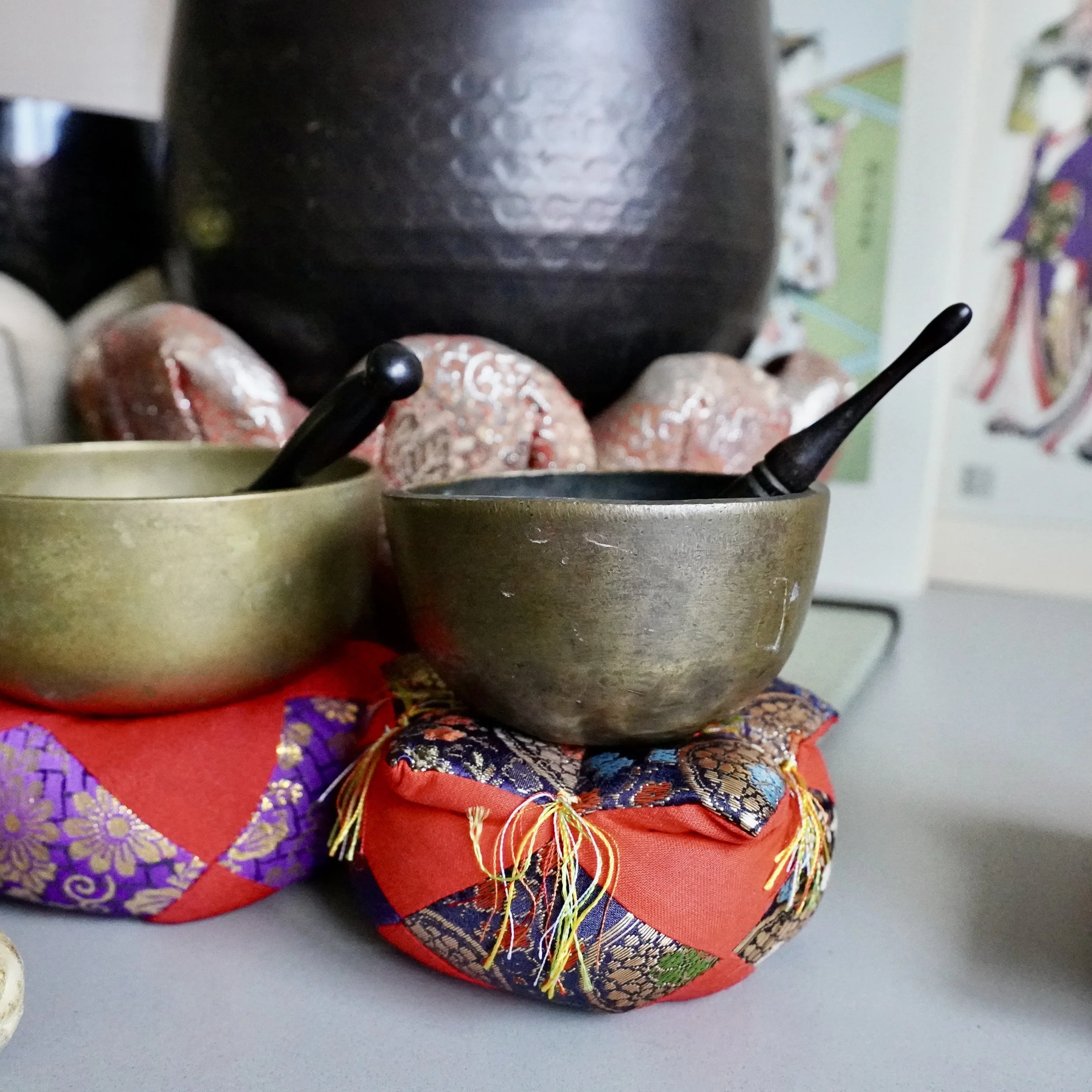 Small bronze orin singing bowl among other Japanese singing bowls, styled group setting