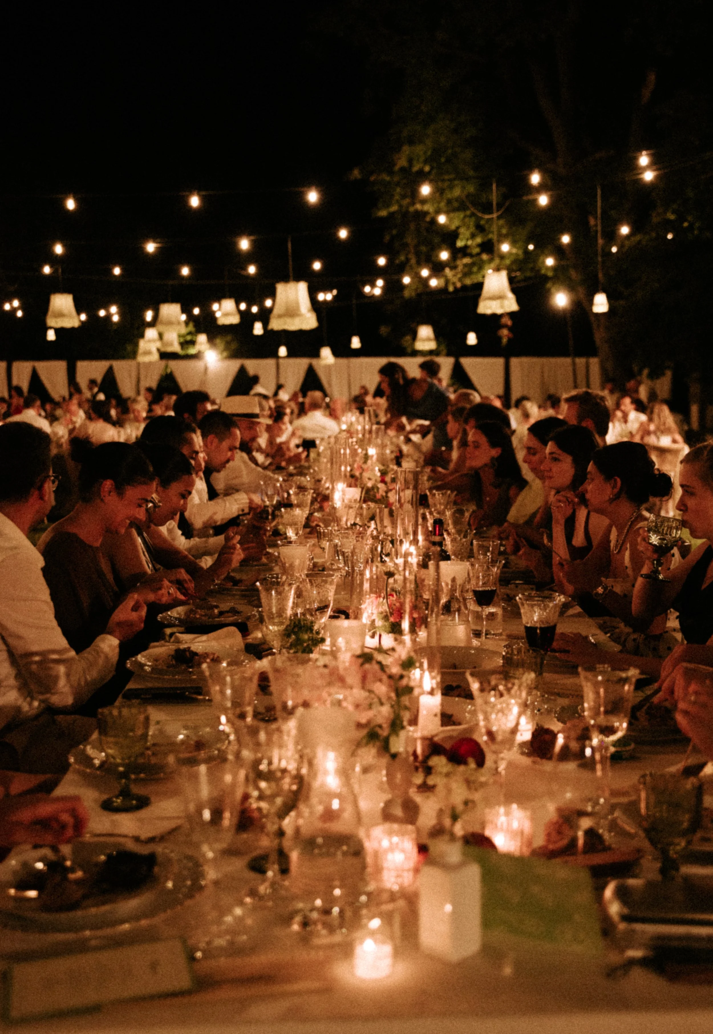 Imperial table at Villa Corsini Mezzomonte , near Florence, Tuscany. It's full of candles and the atmosphere is warm and happy. Bride and groom celebrate with guests.
