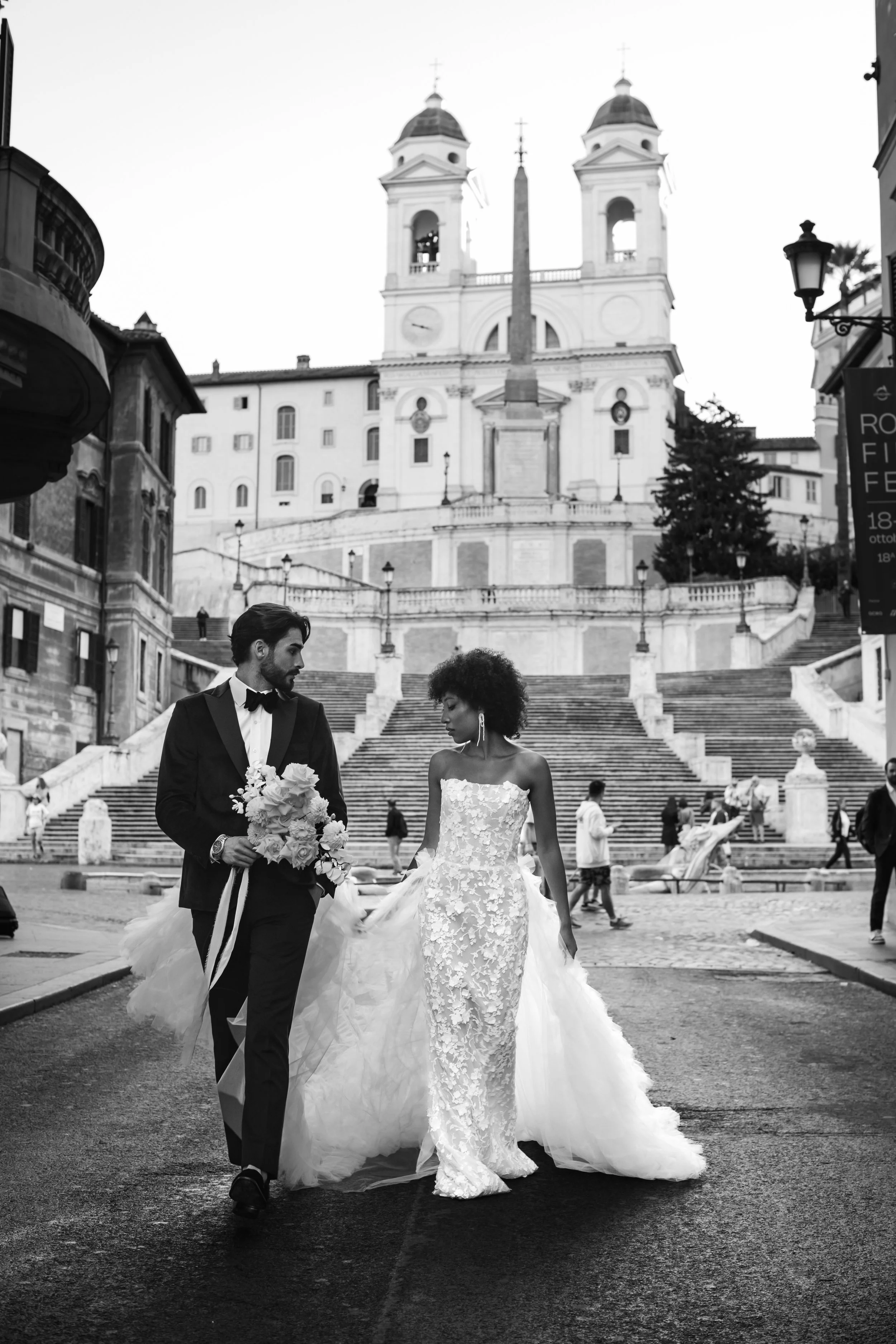 bride and groom, editorial portrait in Via condotti , piazza di spagna, trinità dei monti. Black bride with curly hair.