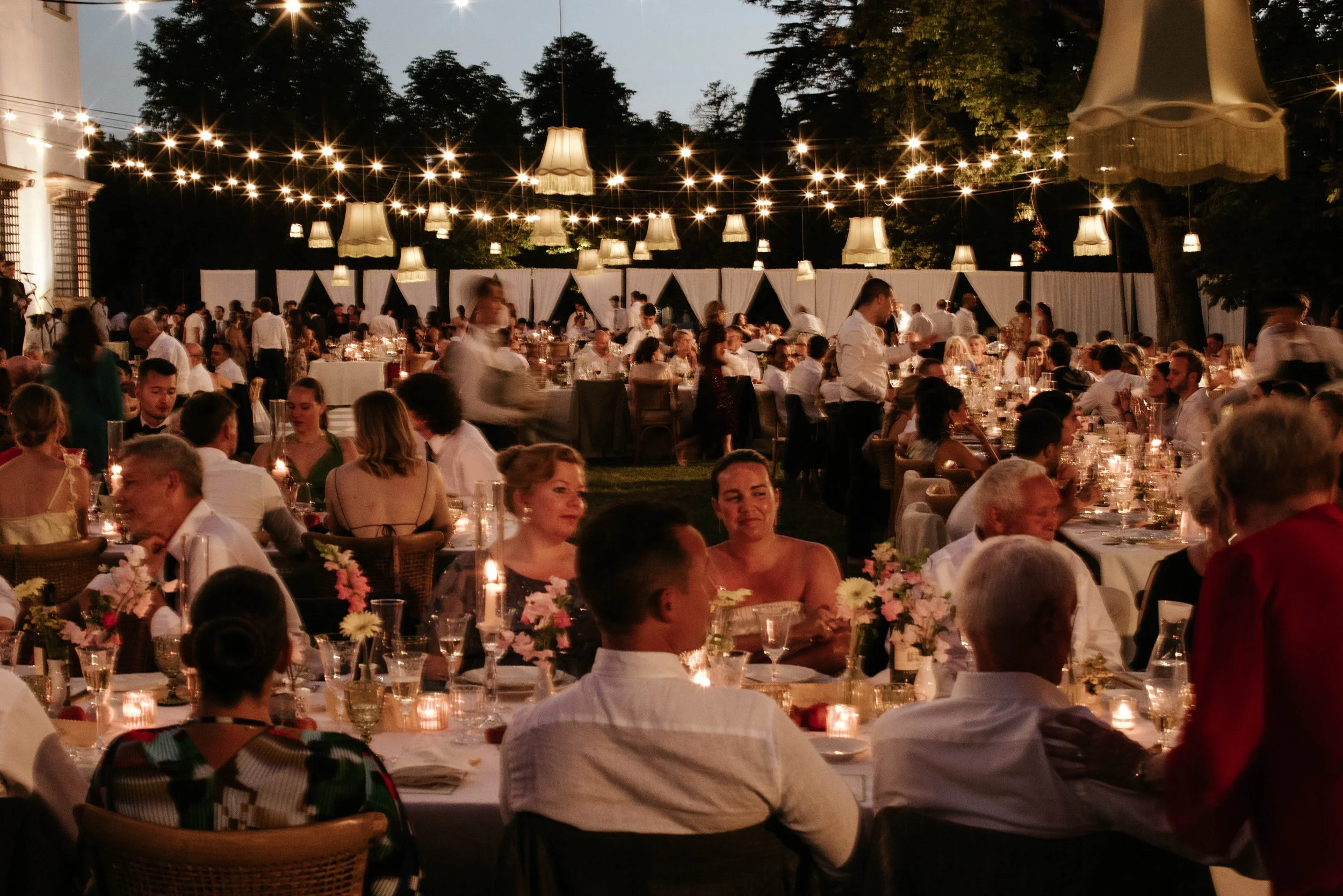 Wedding party and dinner outdoor, candles lights and flowers. Romantic atmosphere in the tuscan countryside. Garden of Villa corsini a mezzomonte.