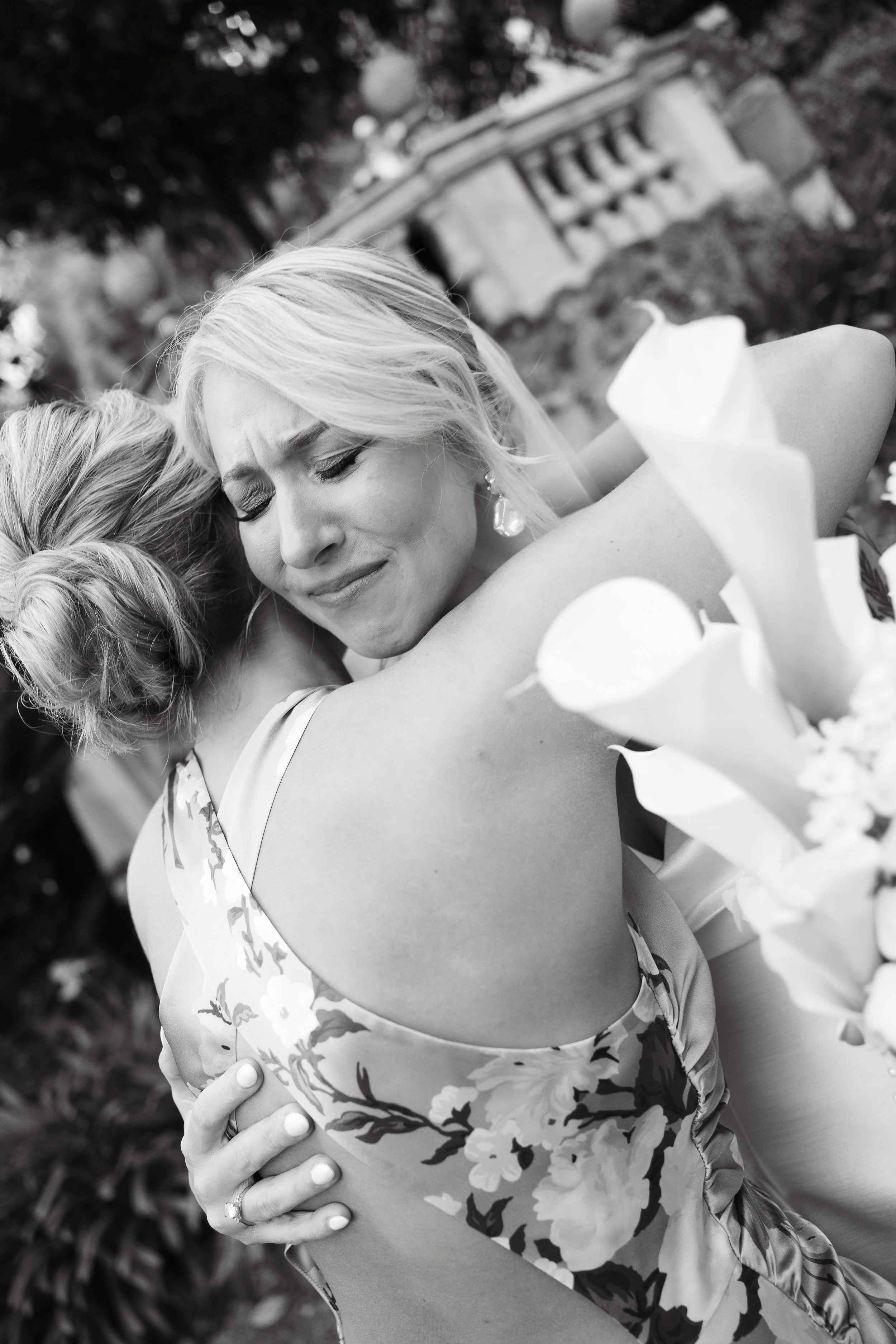 Bride and her sister hug after ceremony at Hotel de Russie , Rome. Bride cries.